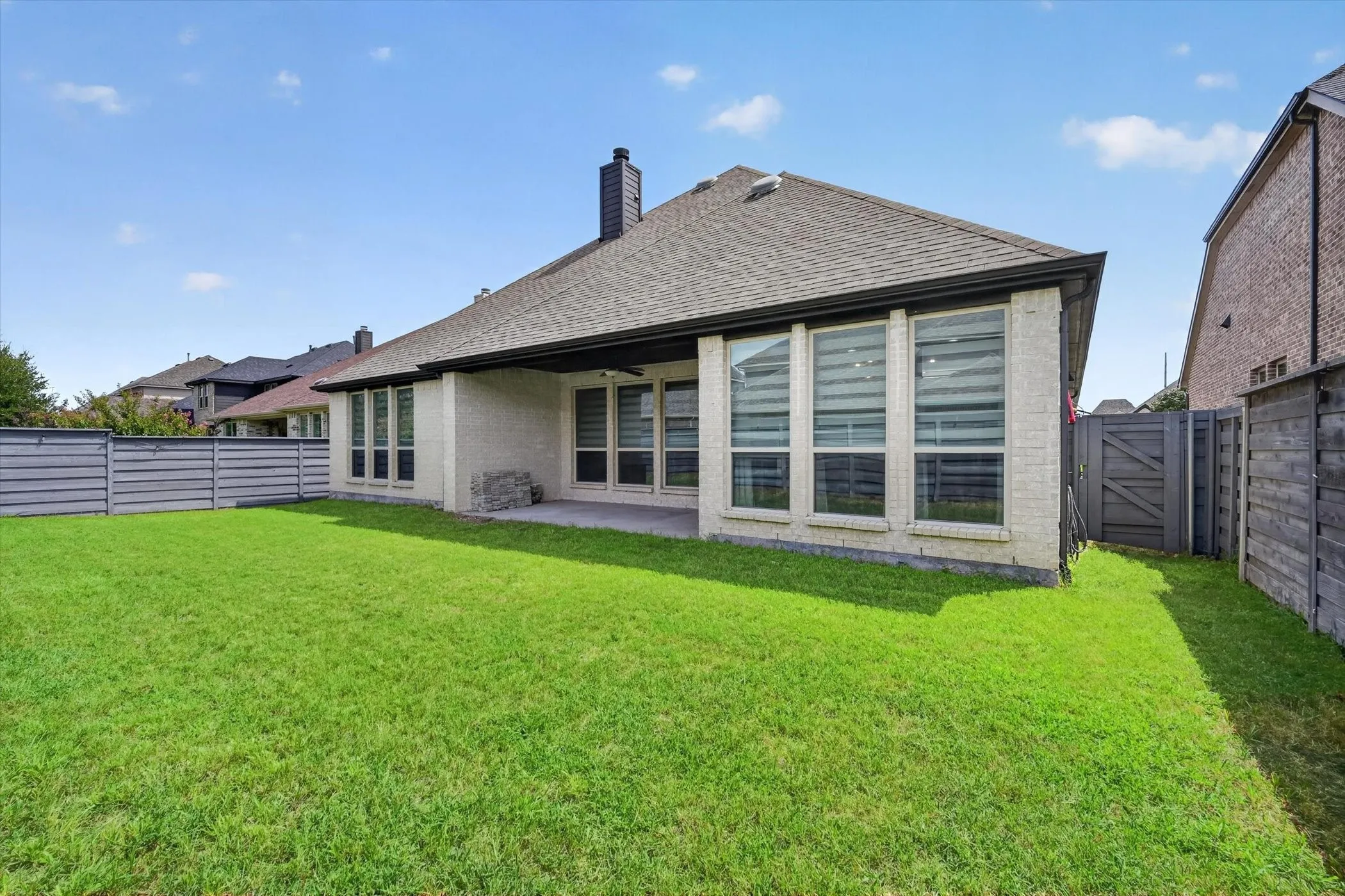 Expansive green lawn with a privacy fence