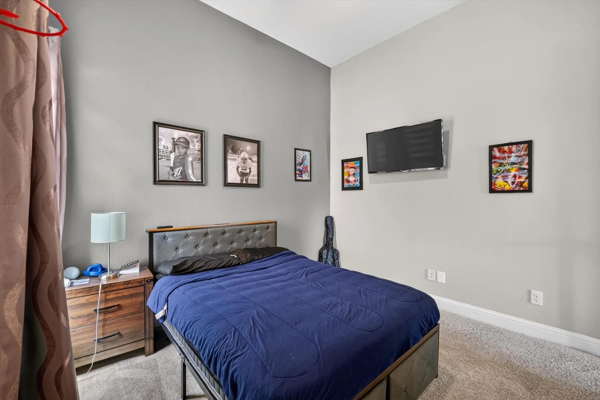 Spacious room featuring vaulted ceilings, light gray wall paint, and gray carpeted flooring