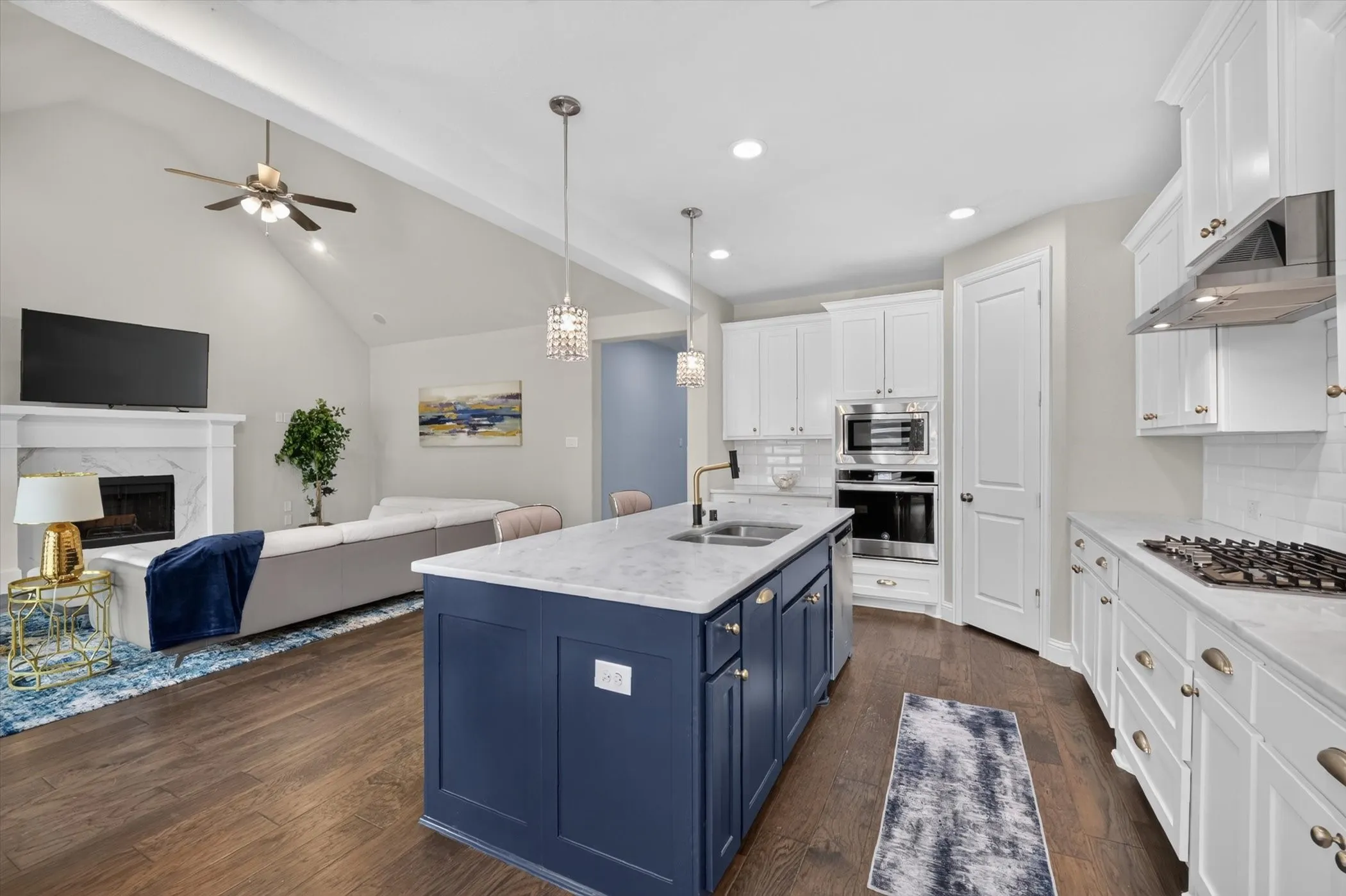 Gourmet kitchen with a blue island, white perimeter cabinetry, stone countertops, and stainless steel appliances