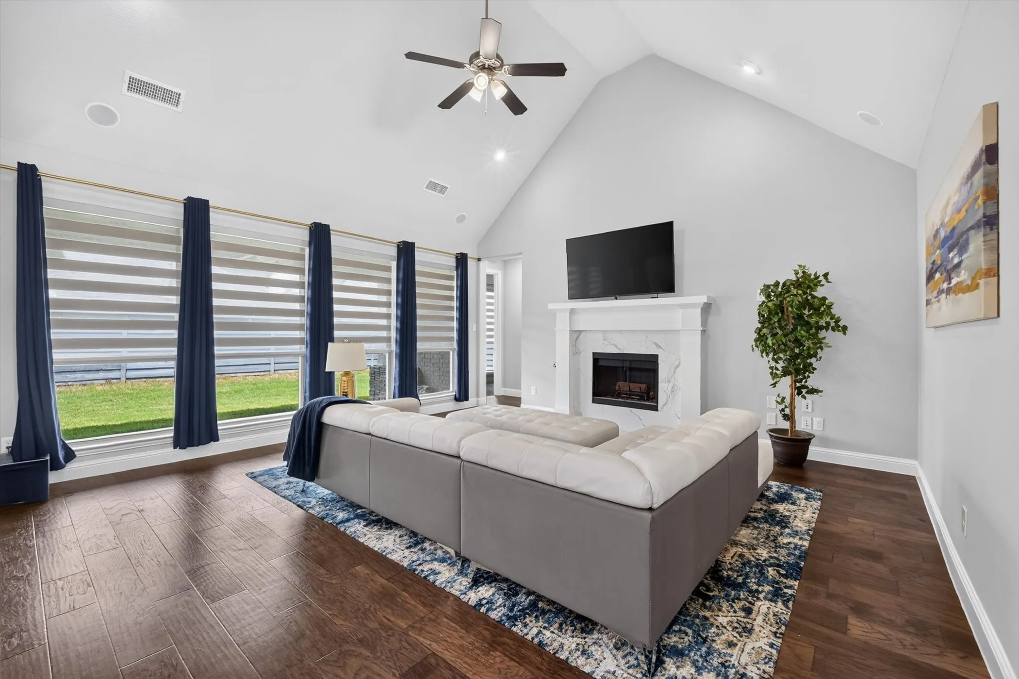 Vaulted ceiling living area featuring rich wood-finish flooring