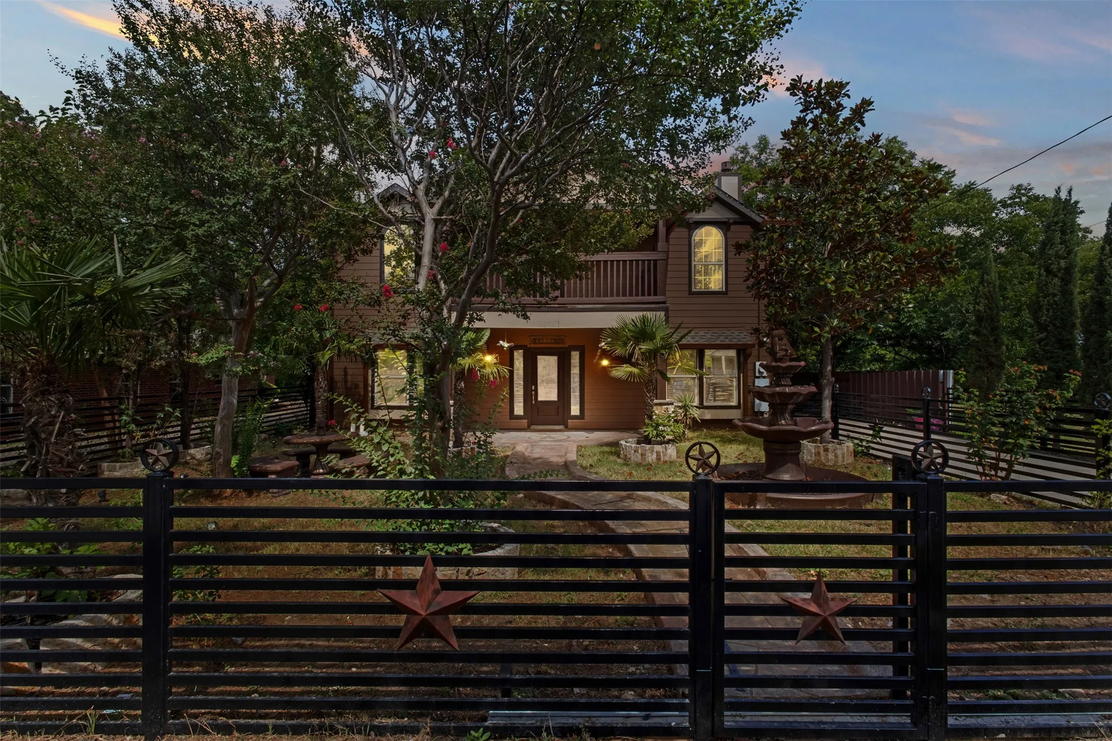 Two-story residence featuring a dark wood-paneled exterior, a second-story balcony, and an arched window