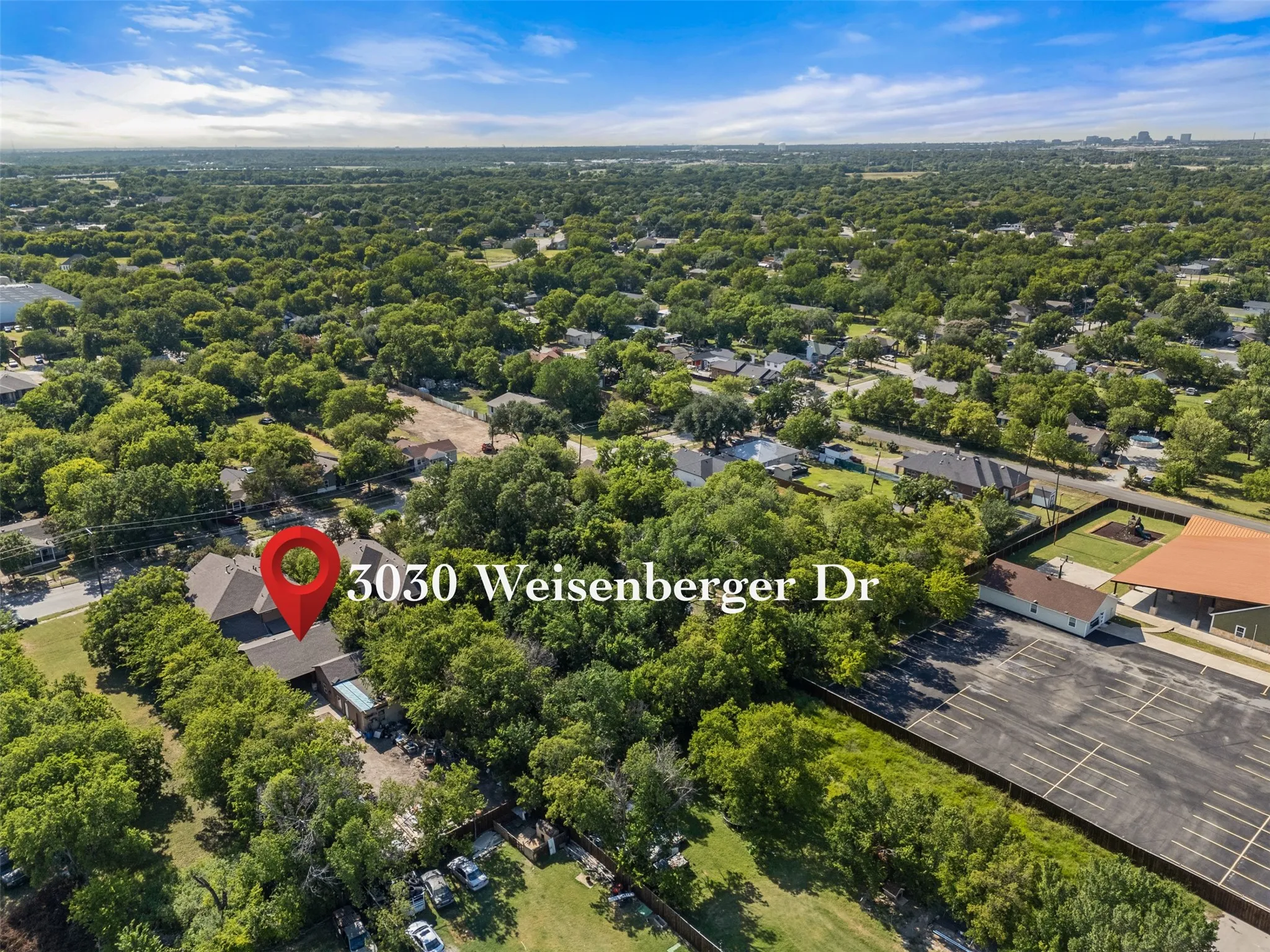 Property situated on a tree-lined lot, featuring a gabled roofline and ample surrounding greenery