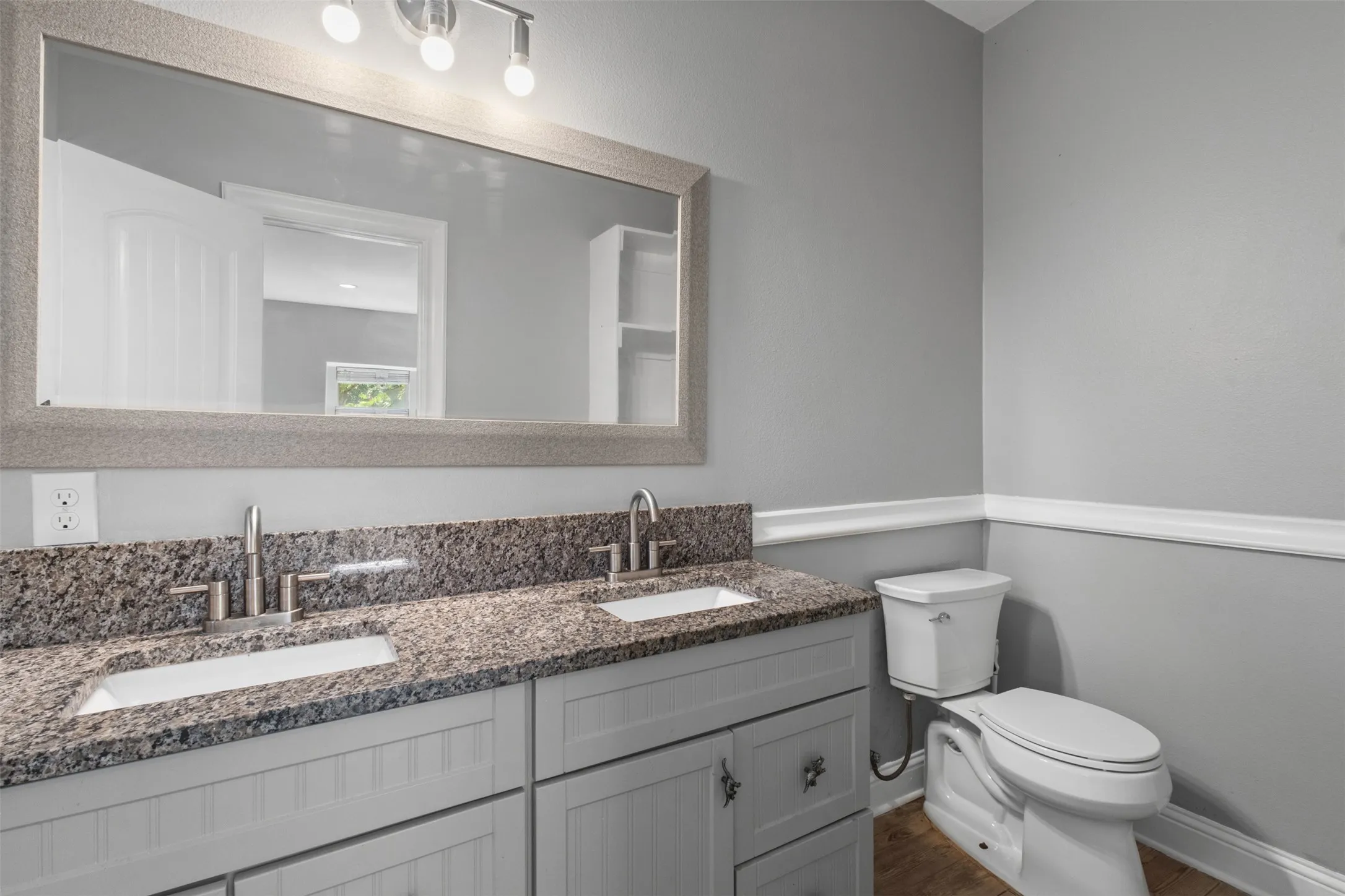 Double vanity with granite countertop, dual undermount sinks, and brushed nickel fixtures