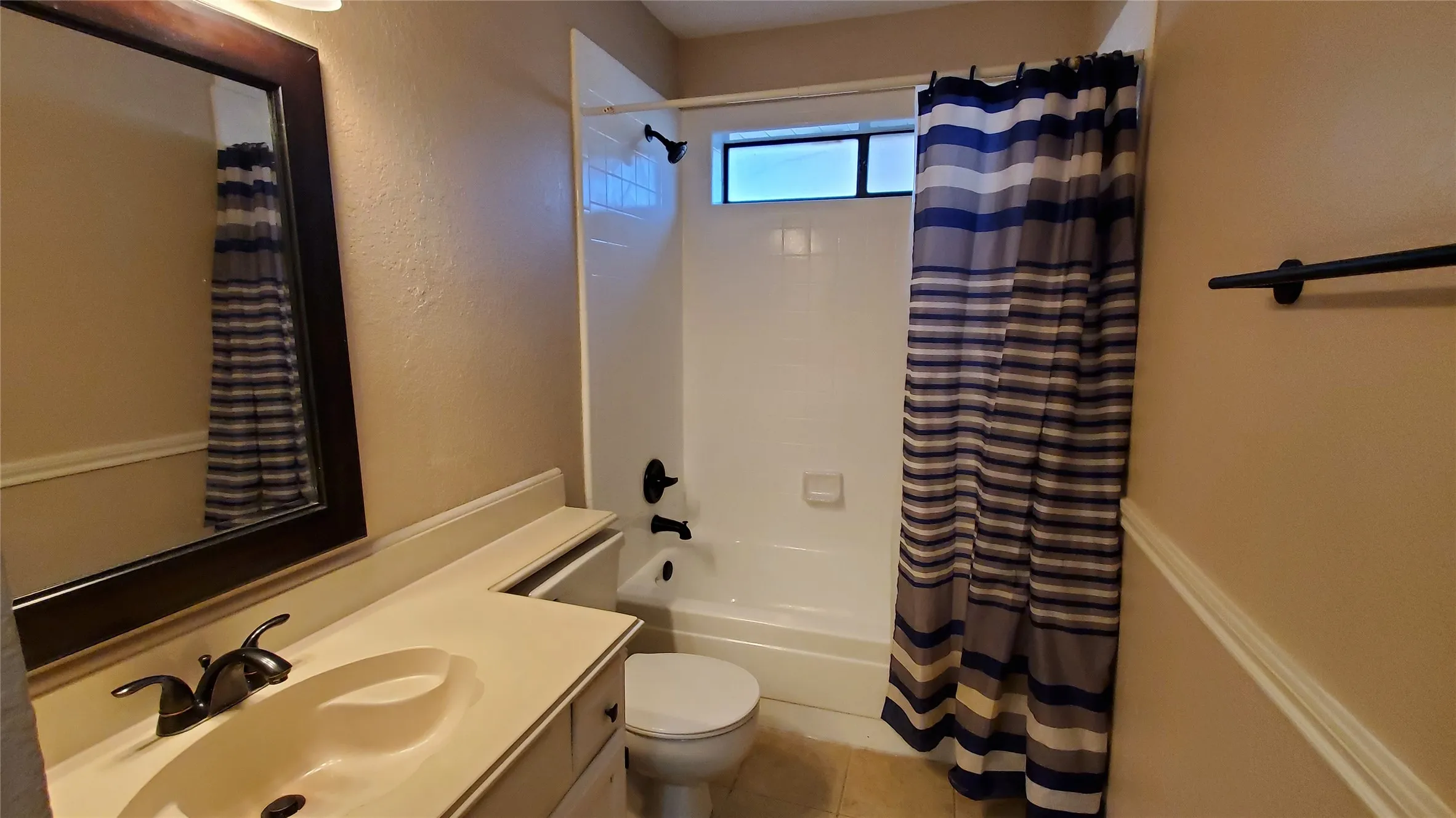 Full bathroom featuring tile patterned flooring, vanity, shower / tub combo with curtain, and toilet