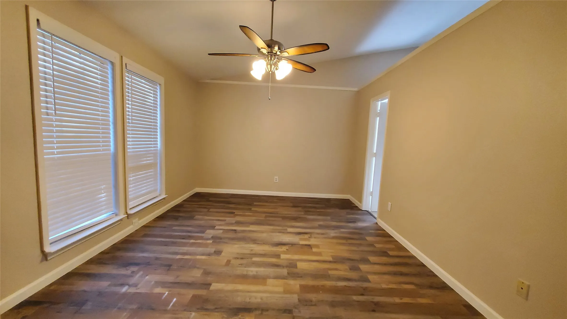 Unfurnished room with ceiling fan, lofted ceiling, and dark wood-type flooring