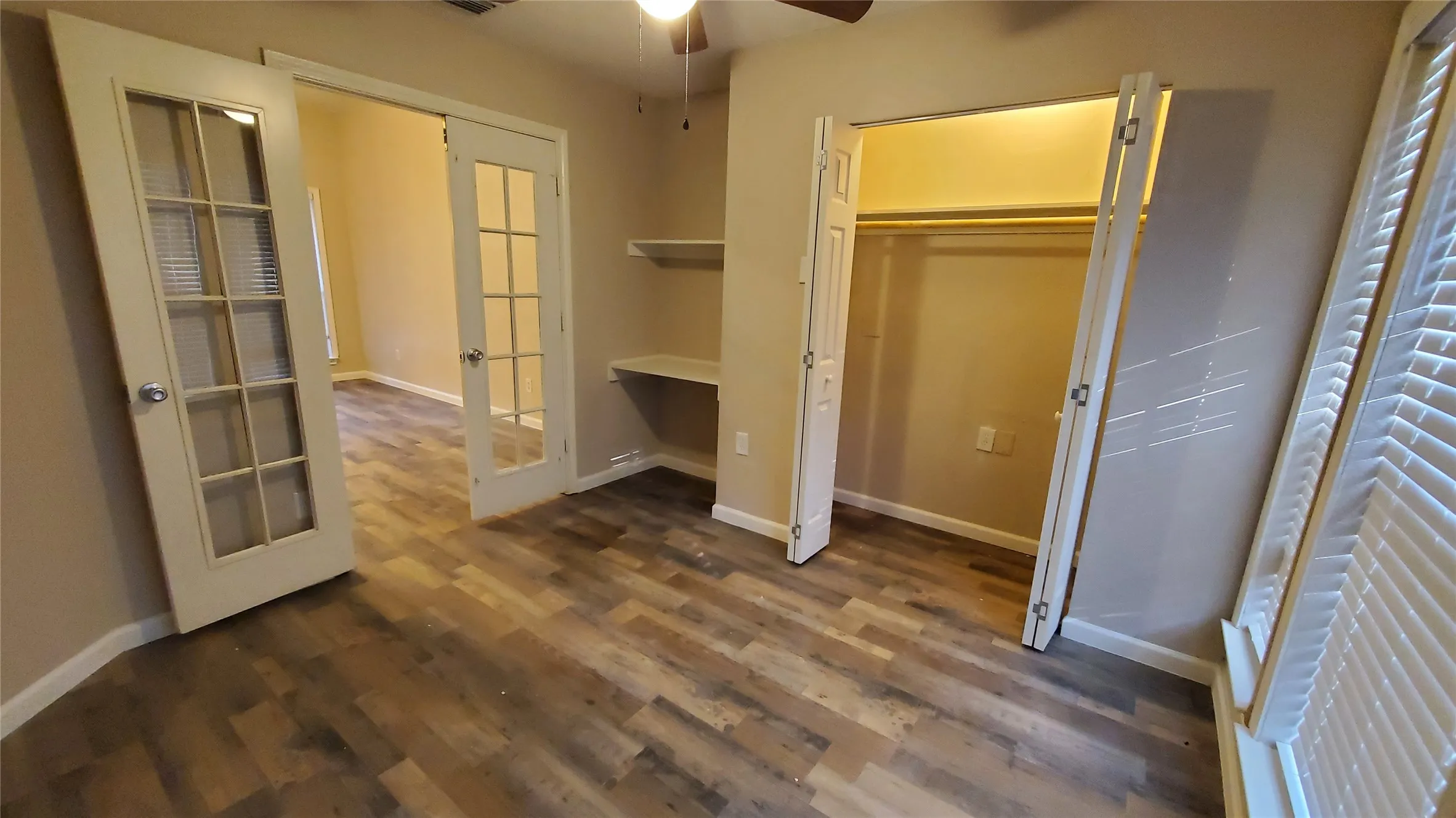 Bedroom 4 with ceiling fan, study desk, and french doors.