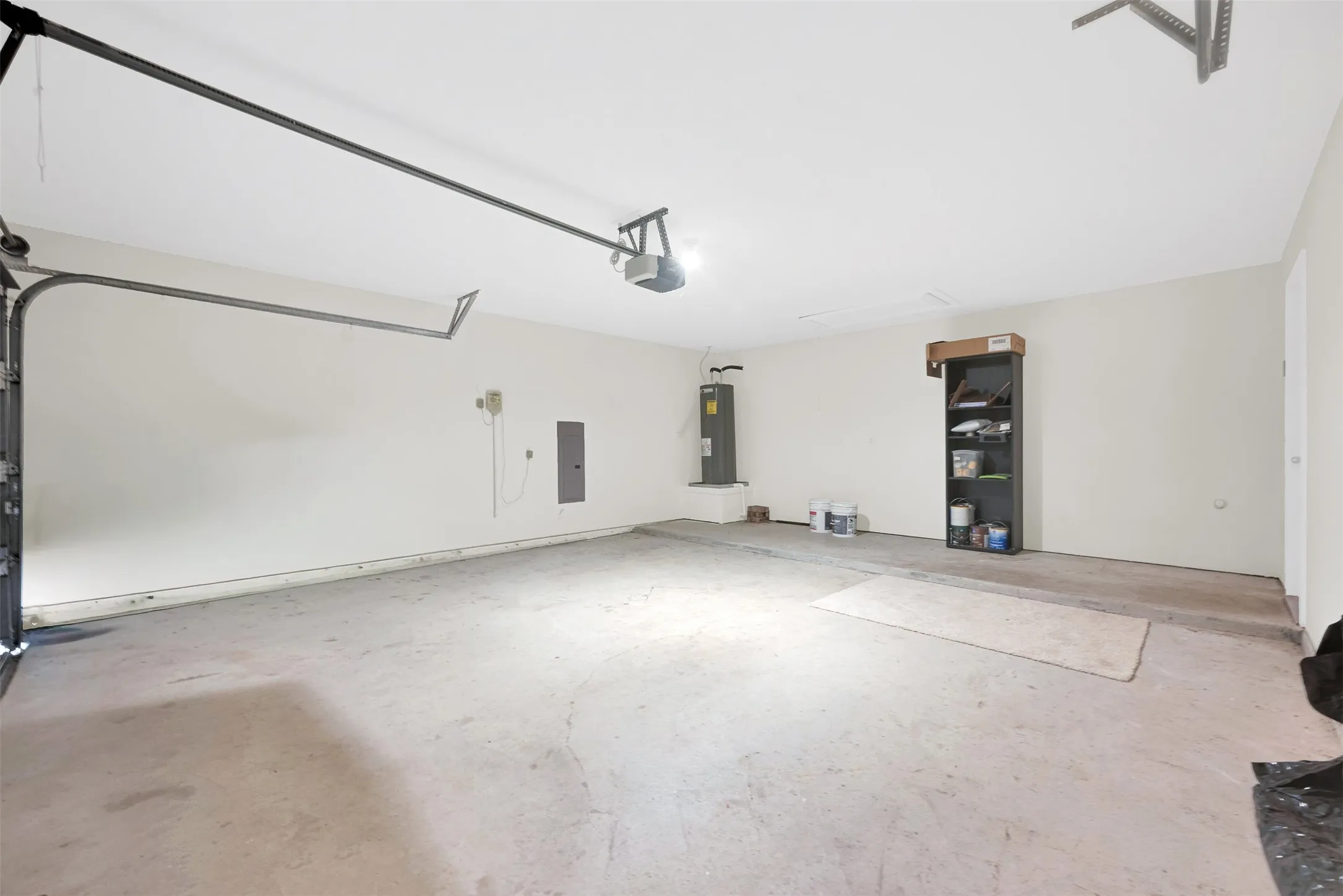 Spacious garage featuring a concrete floor, painted walls, and an overhead garage door opener mechanism