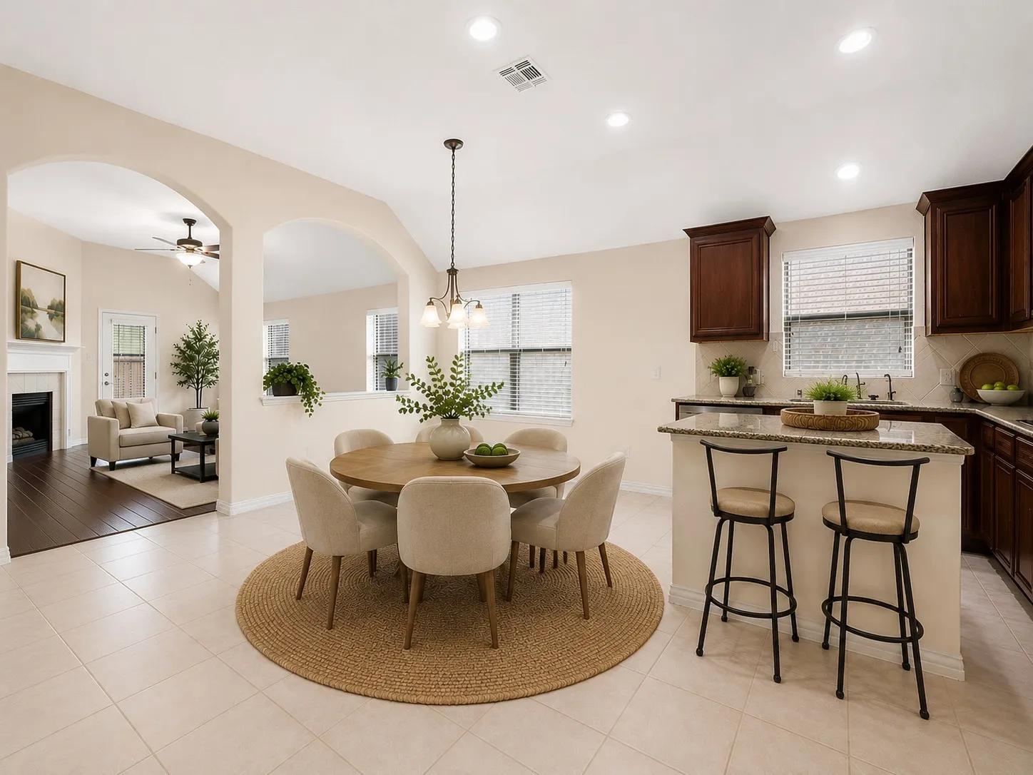 Open-concept living space featuring light-toned tile flooring and arched doorways