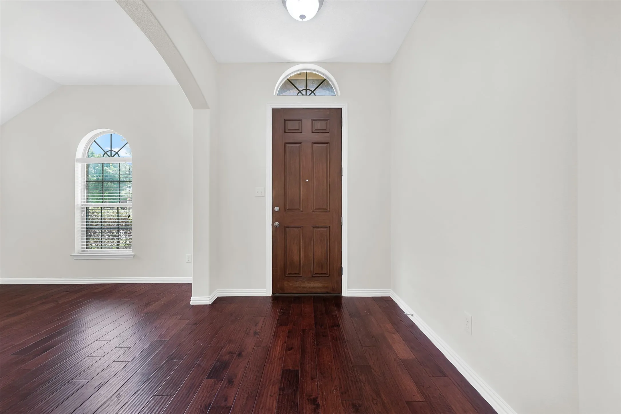 Rich wood-finish flooring extending from the entryway