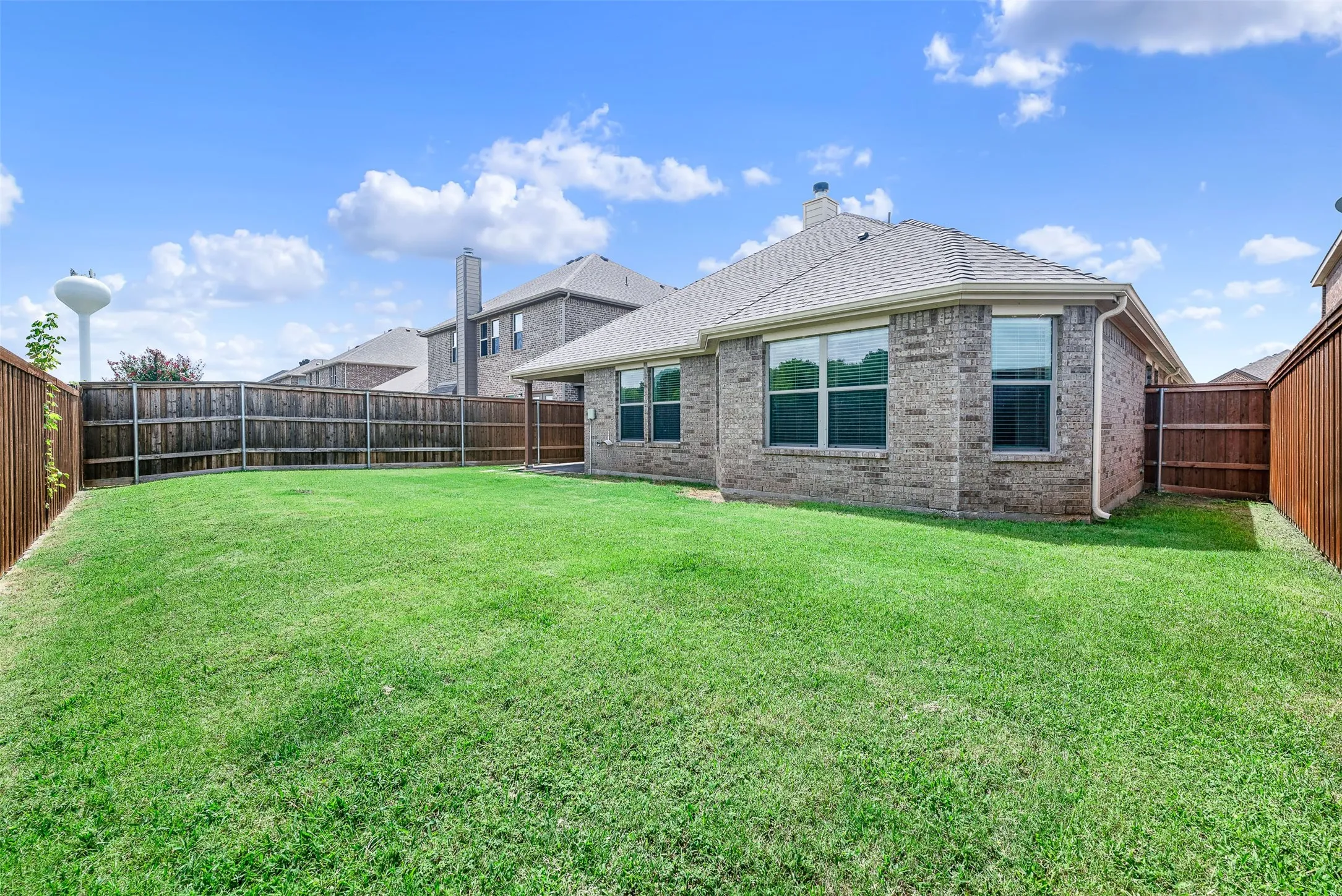 Expansive lawn bordered by a wood privacy fence