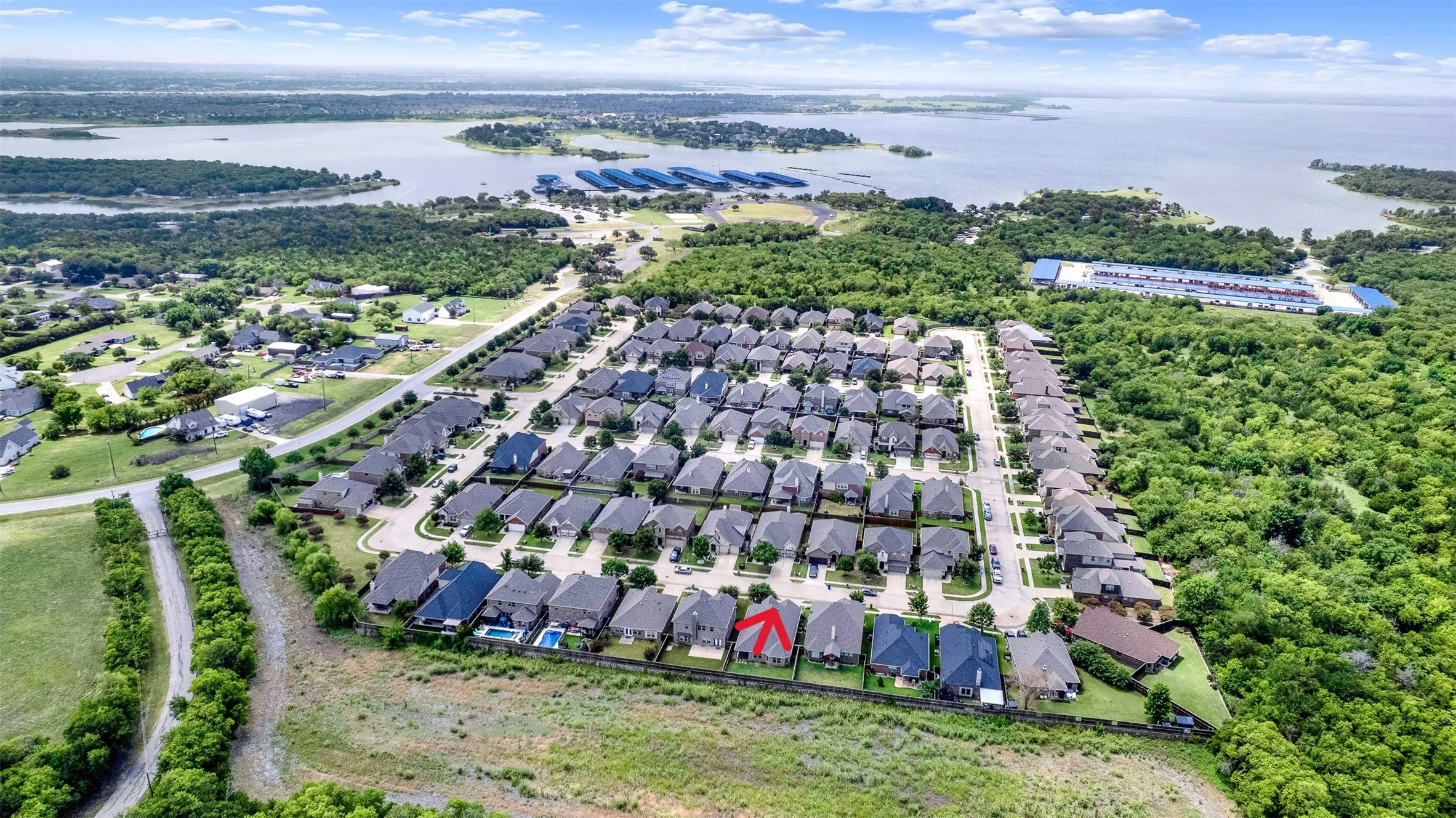 Aerial perspective showcasing a residential community situated near a significant body of water
