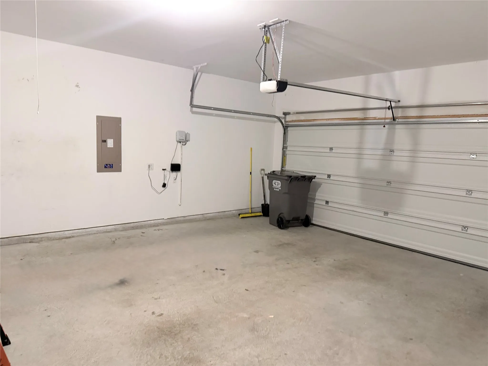 Spacious garage featuring a concrete floor, painted walls, and an automatic overhead door opener