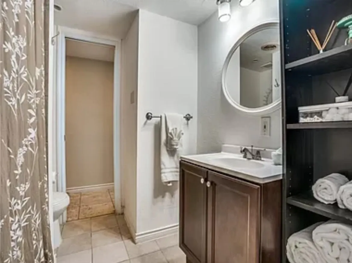 Bathroom with tile flooring, toilet, and large vanity