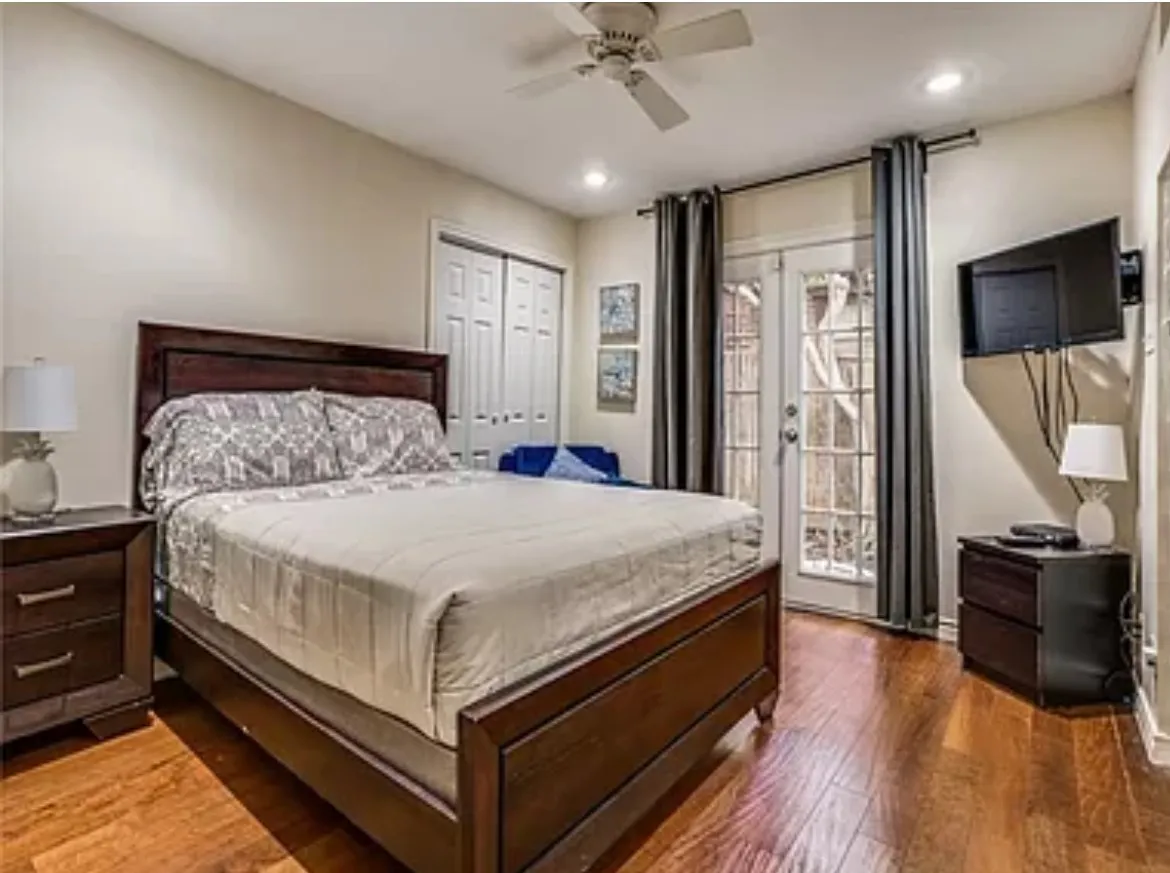 Bedroom featuring access to outside, french doors, dark wood-type flooring, and ceiling fan