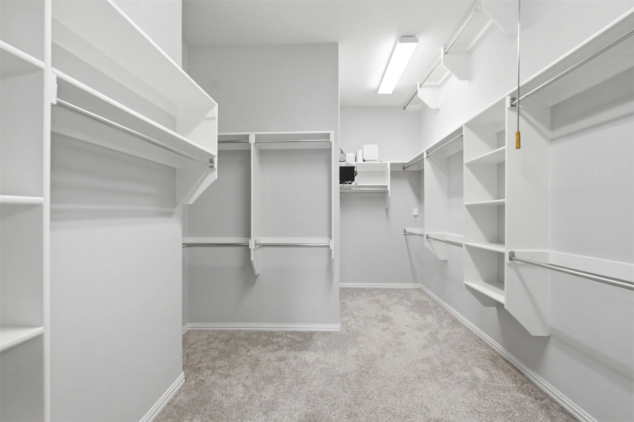 Primary closet with shelving and 3-tier closet rod