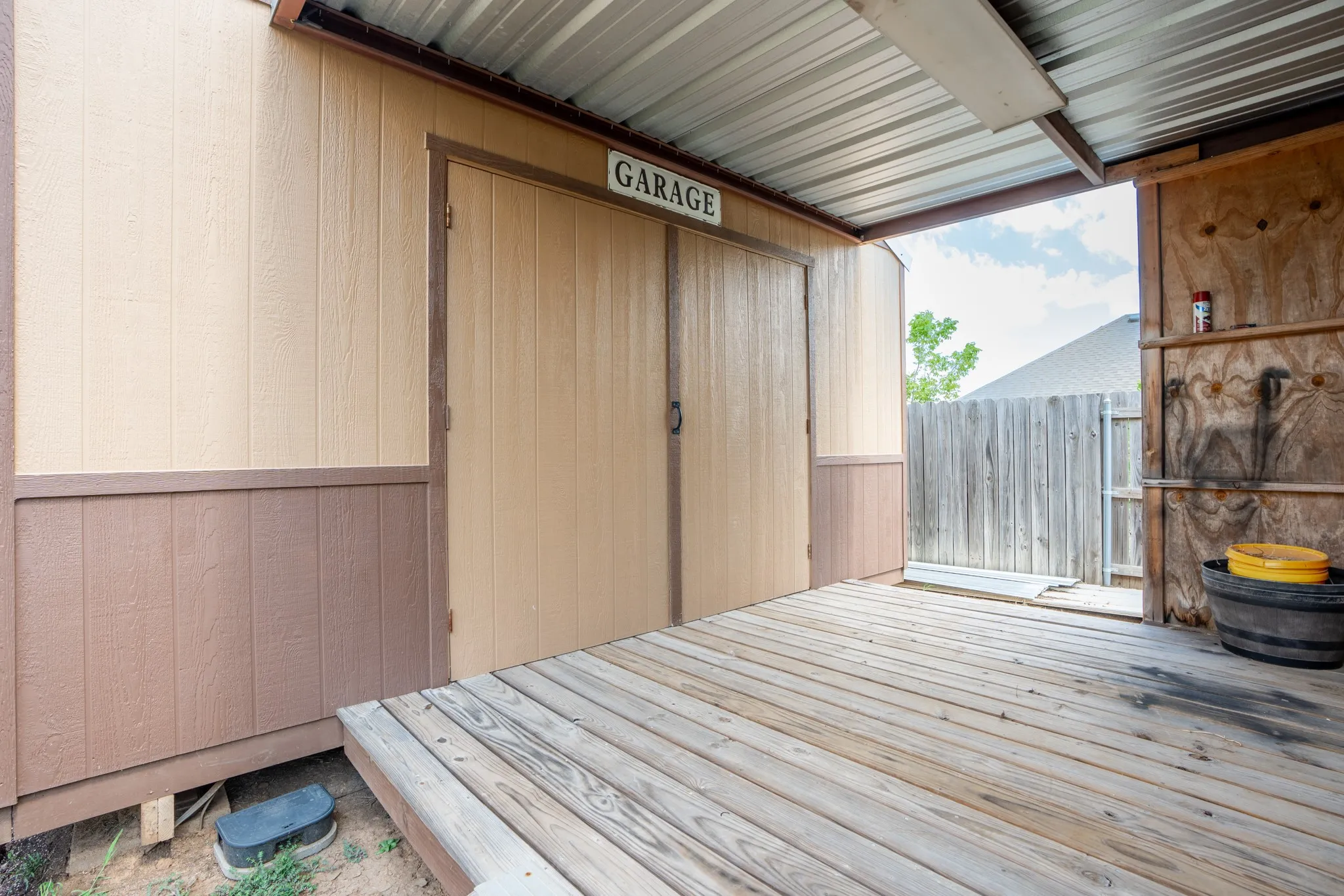 Covered outdoor space featuring a wood-plank deck