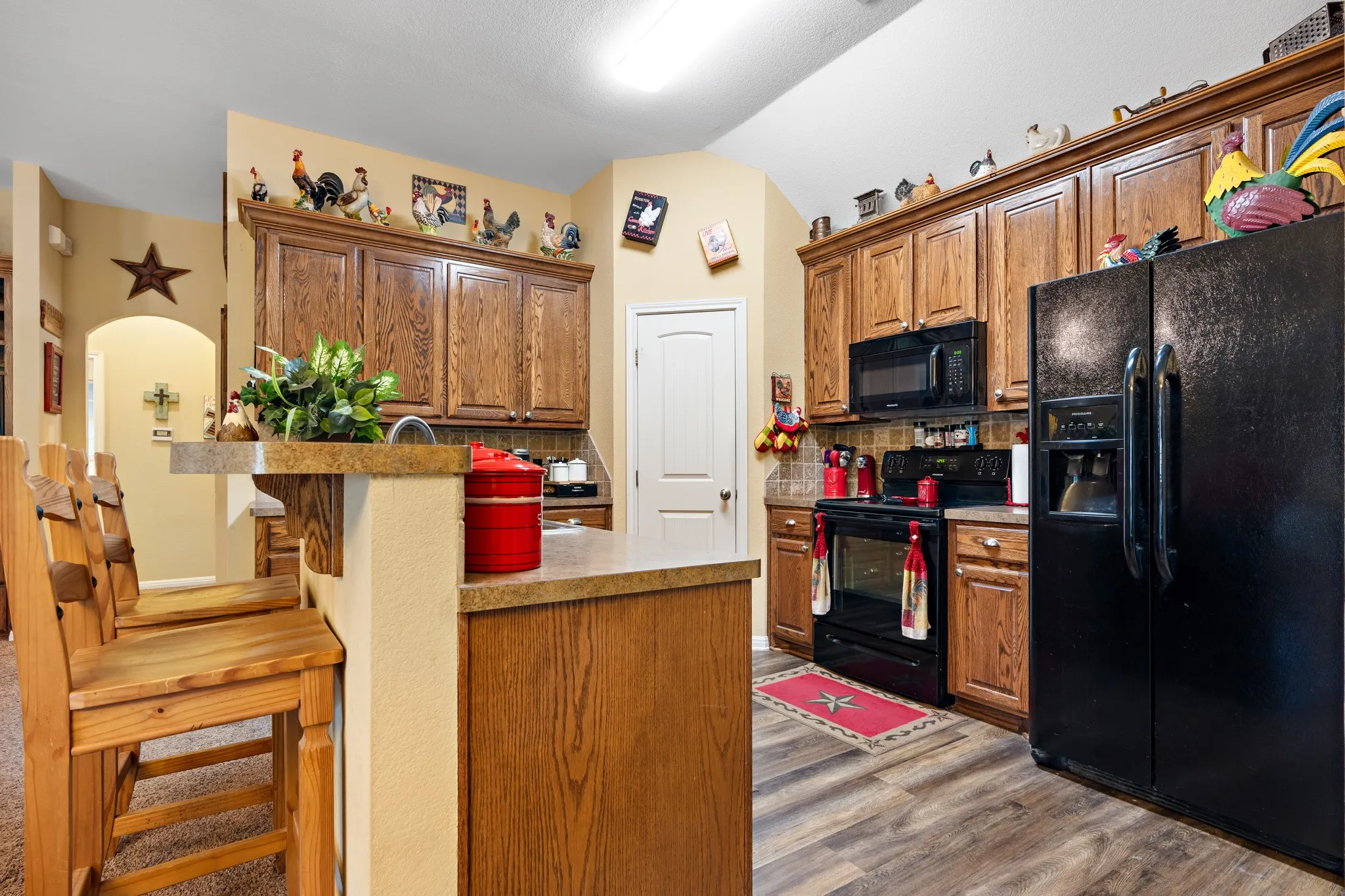 Kitchen featuring wood-finish flooring, dark wood cabinetry, and a double-basin sink