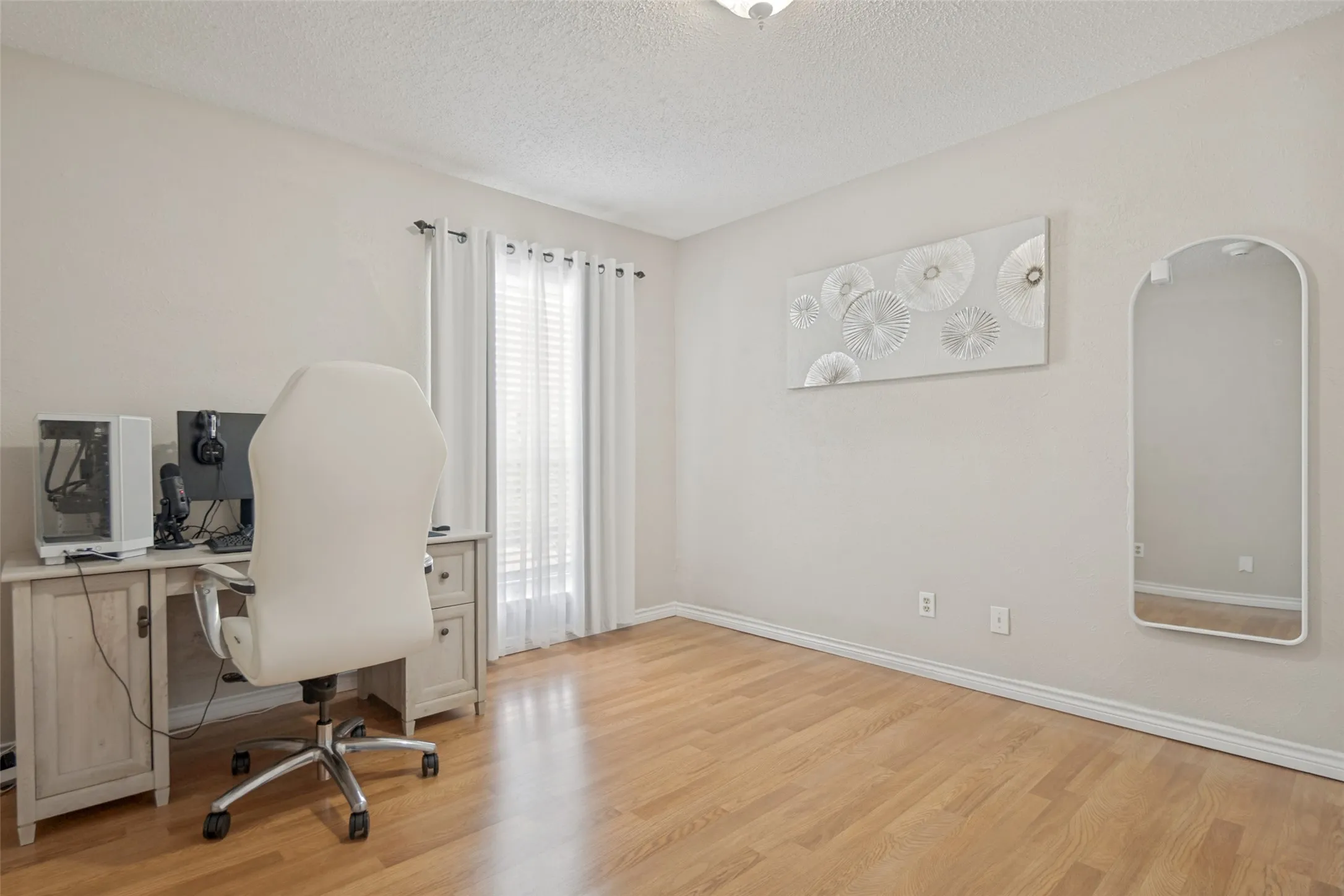 Room featuring wood-finish flooring, neutral wall tones, and white baseboards