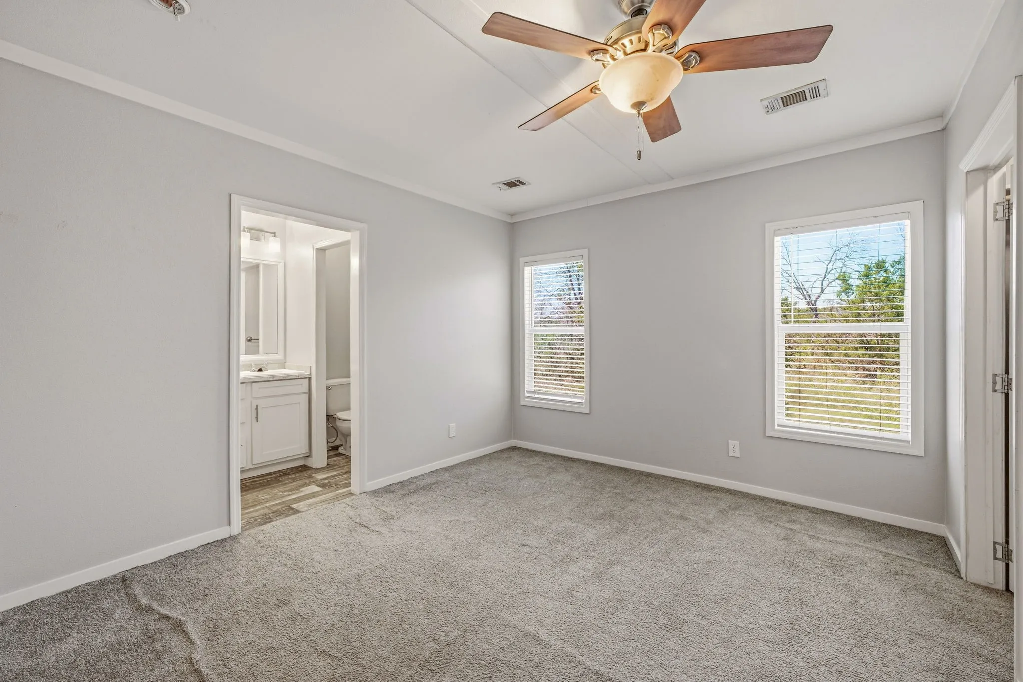 Bedroom featuring light gray wall paint, gray carpet flooring, and white trim