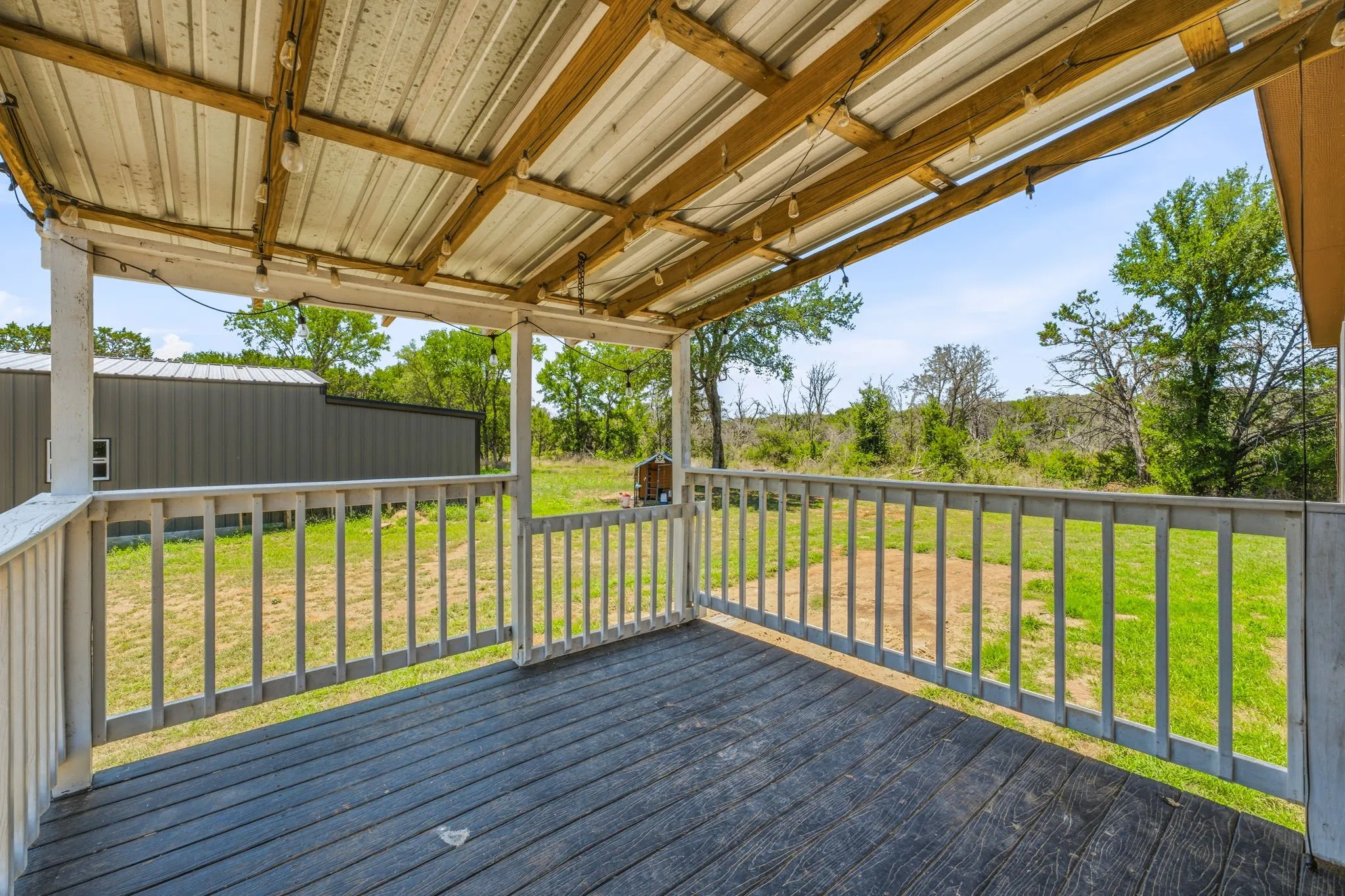 Covered porch featuring a wood-finish floor and white wood railings