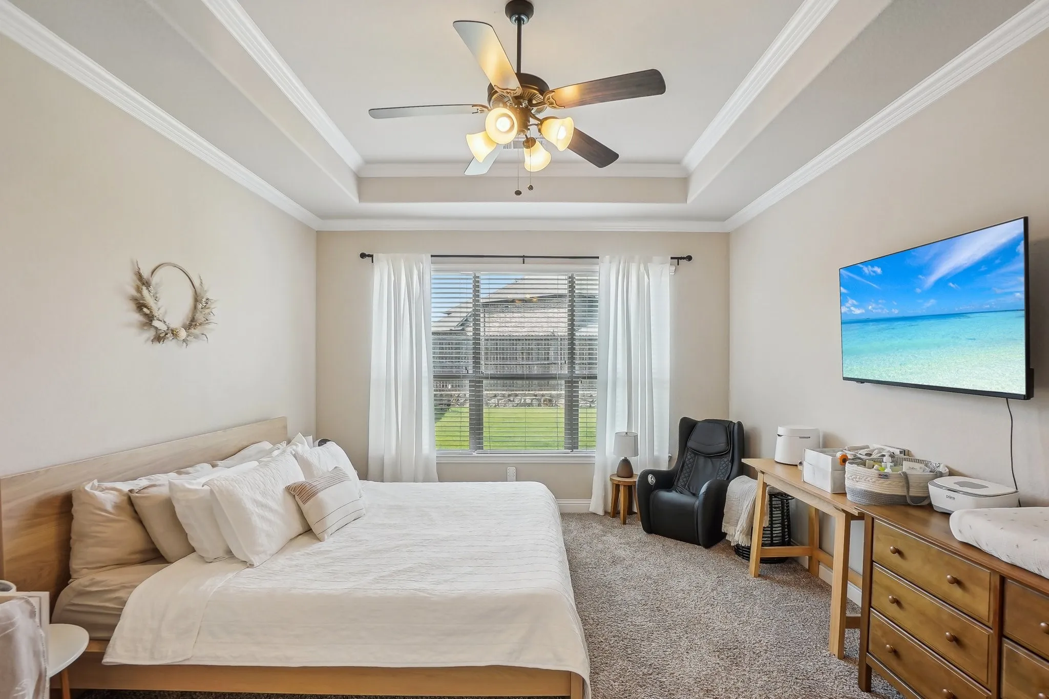 Bedroom featuring carpet floors, crown molding, ceiling fan, and a raised ceiling