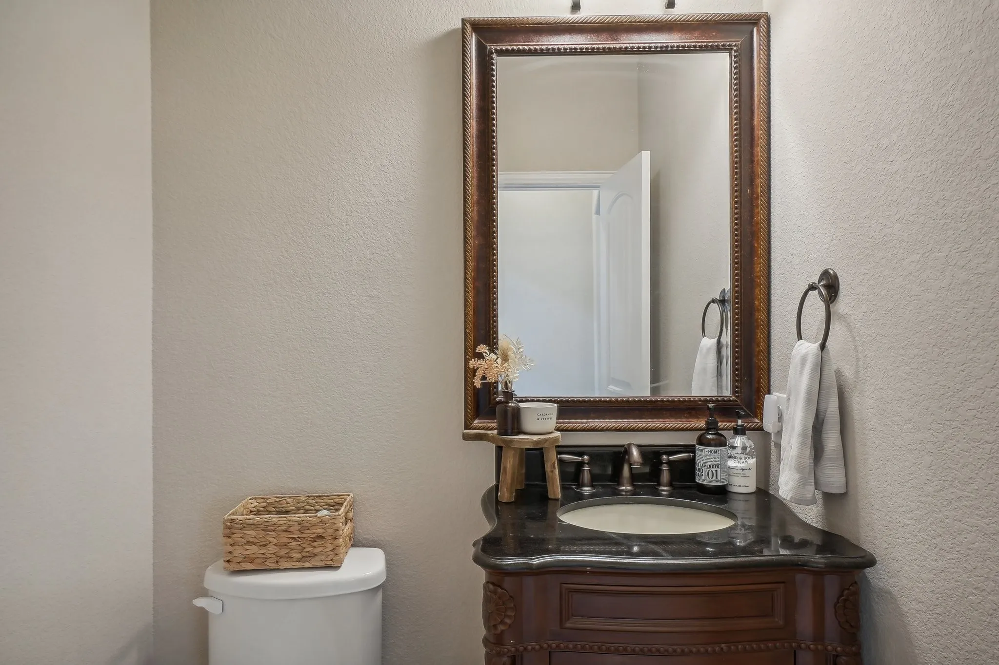Bathroom with a textured wall and vanity