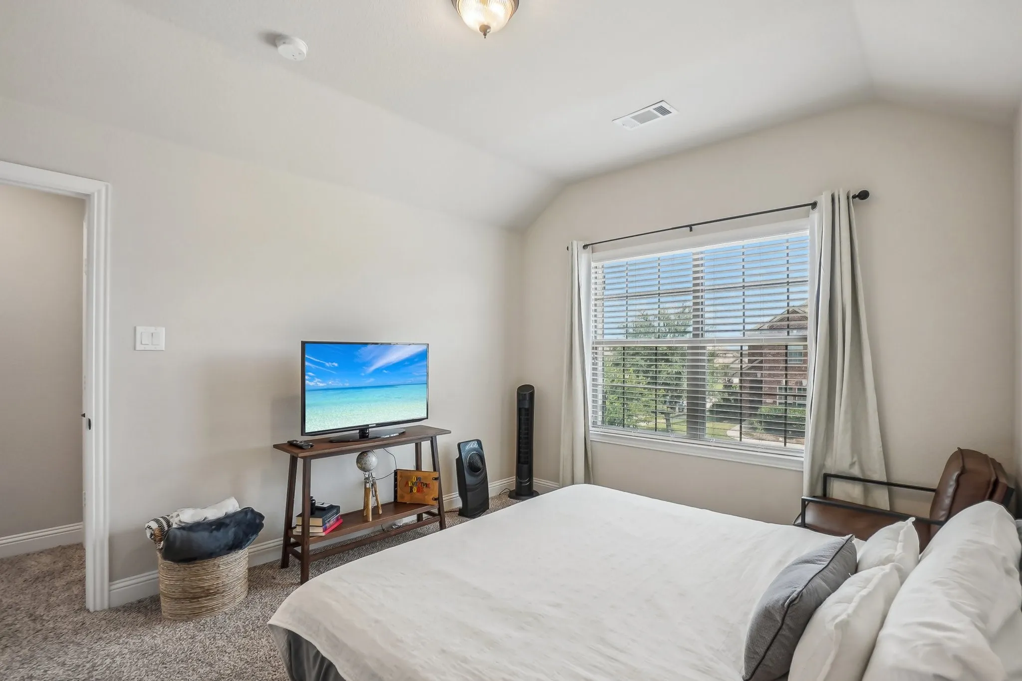 Carpeted bedroom with lofted ceiling and baseboards