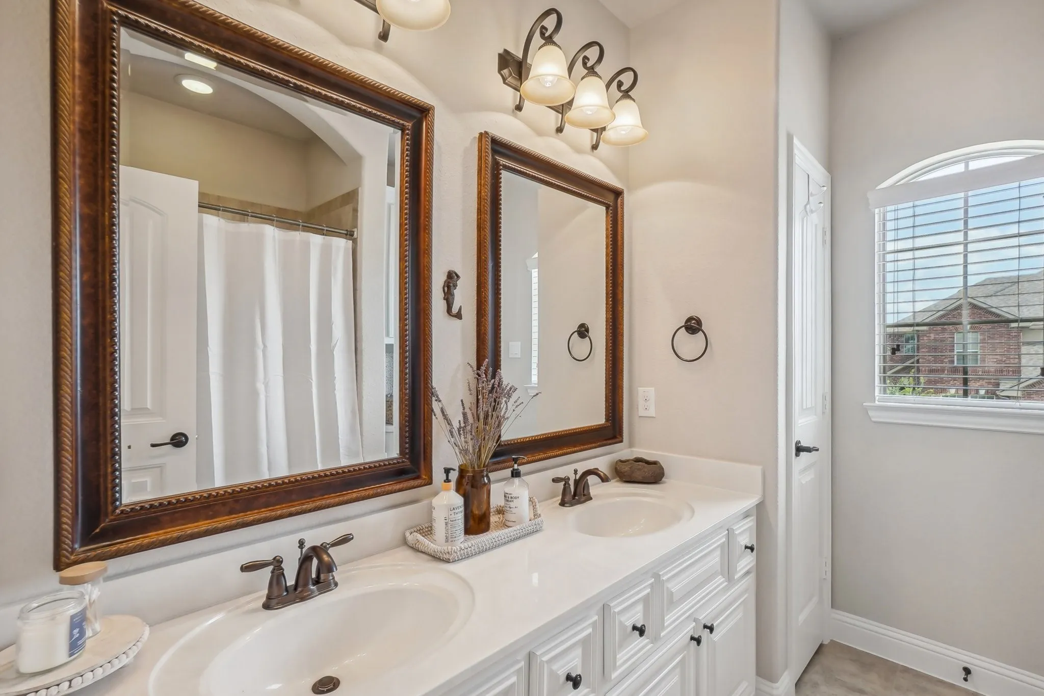 Bathroom featuring curtained shower and double vanity
