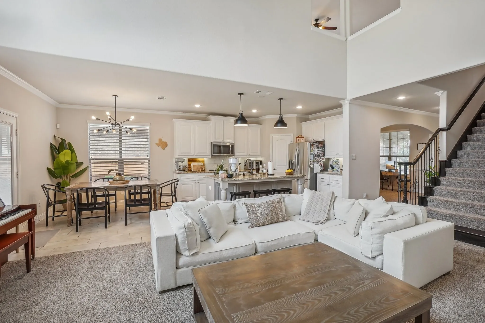 Living room featuring ornamental molding, stairs, a chandelier, and recessed lighting