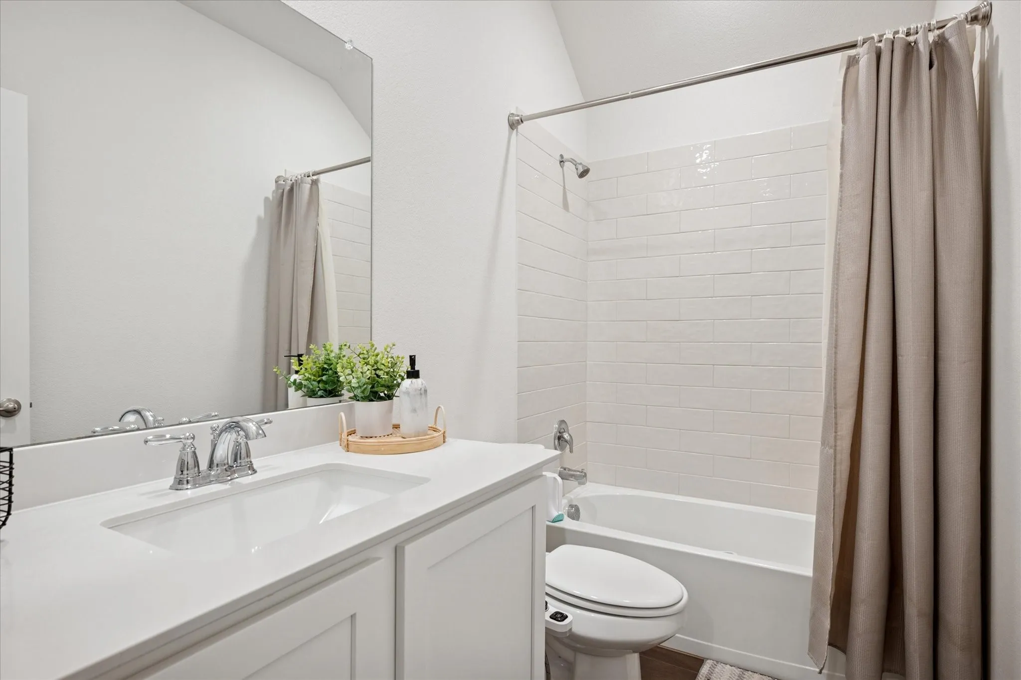 Bathroom featuring a single vanity with an integrated sink, polished chrome faucet, and white cabinetry