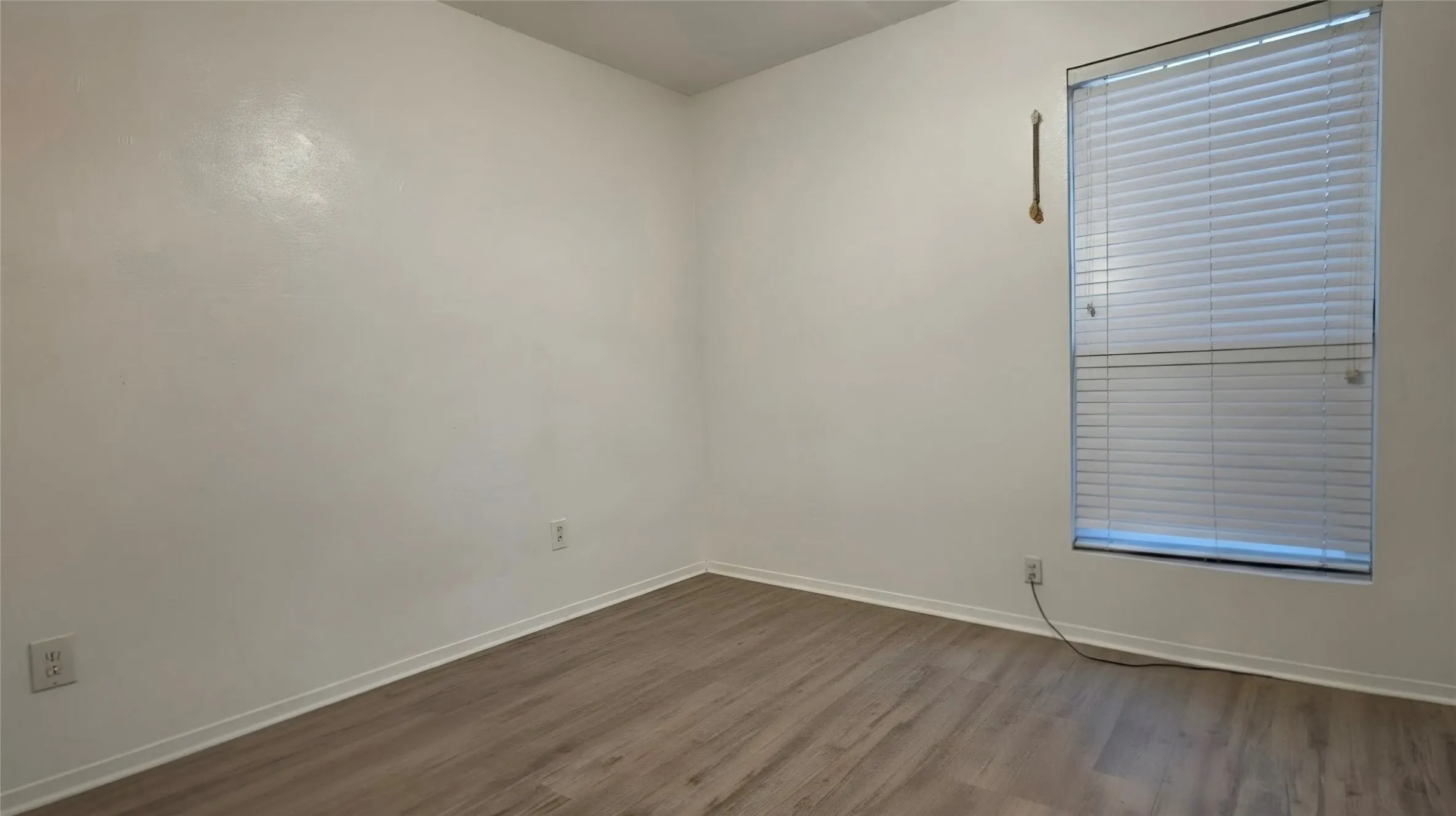 Neutral wall paint throughout featuring wood-finish flooring