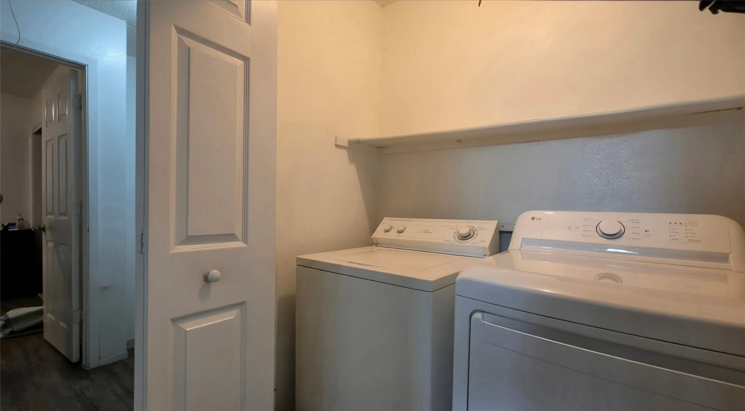 Laundry area featuring a built-in shelf and white wall paint