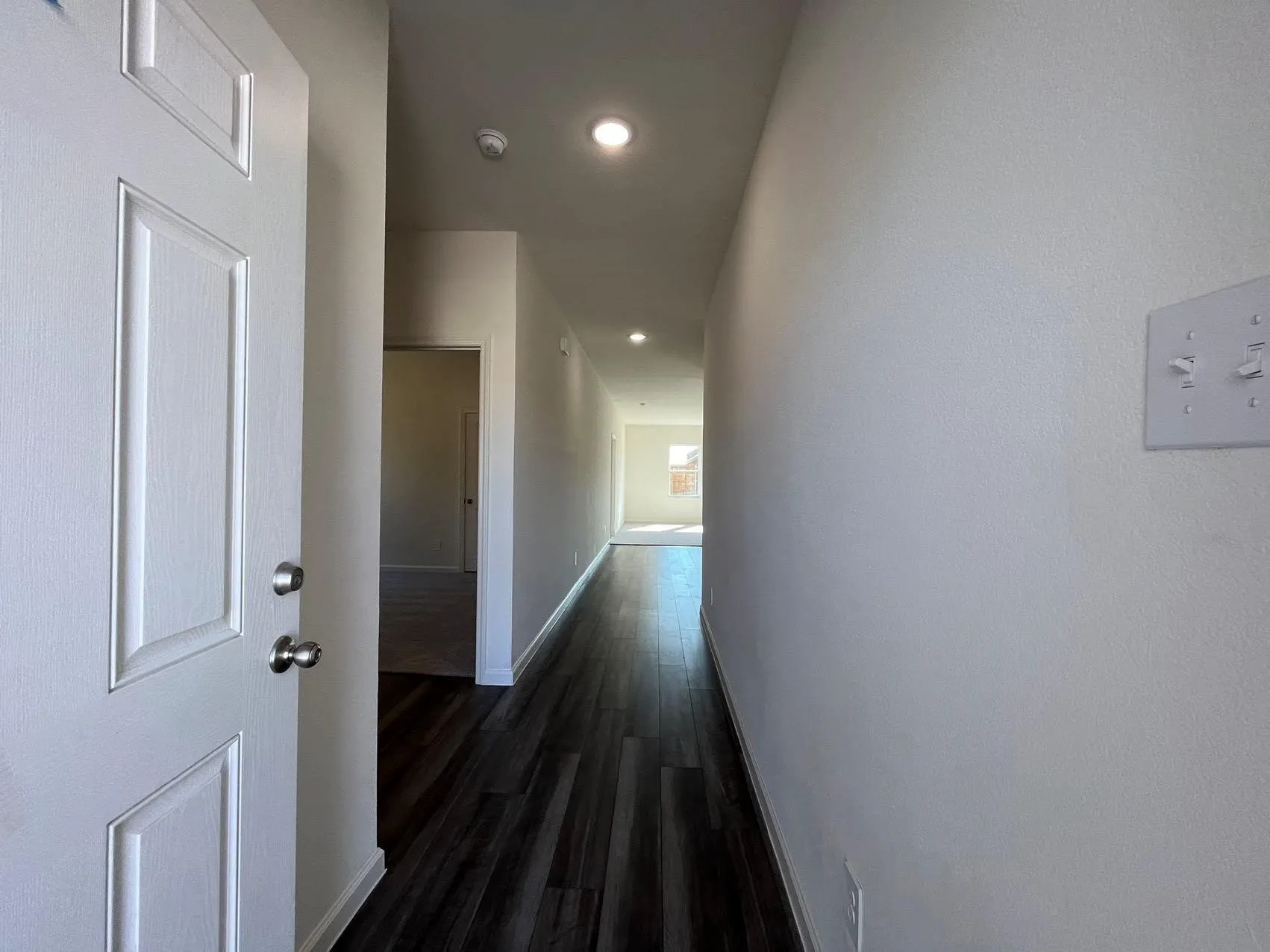 Corridor with dark wood finished floors and recessed lighting