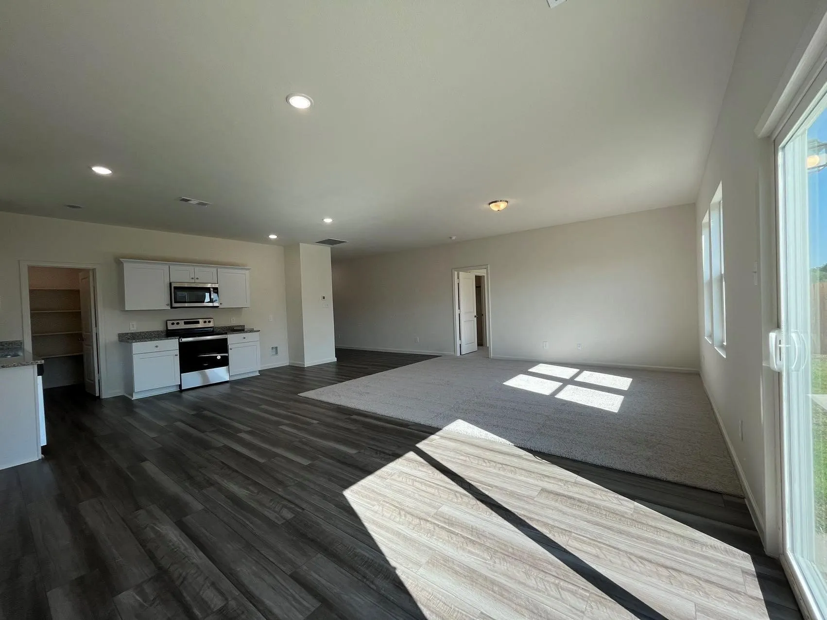 Unfurnished living room with recessed lighting and dark wood finished floors