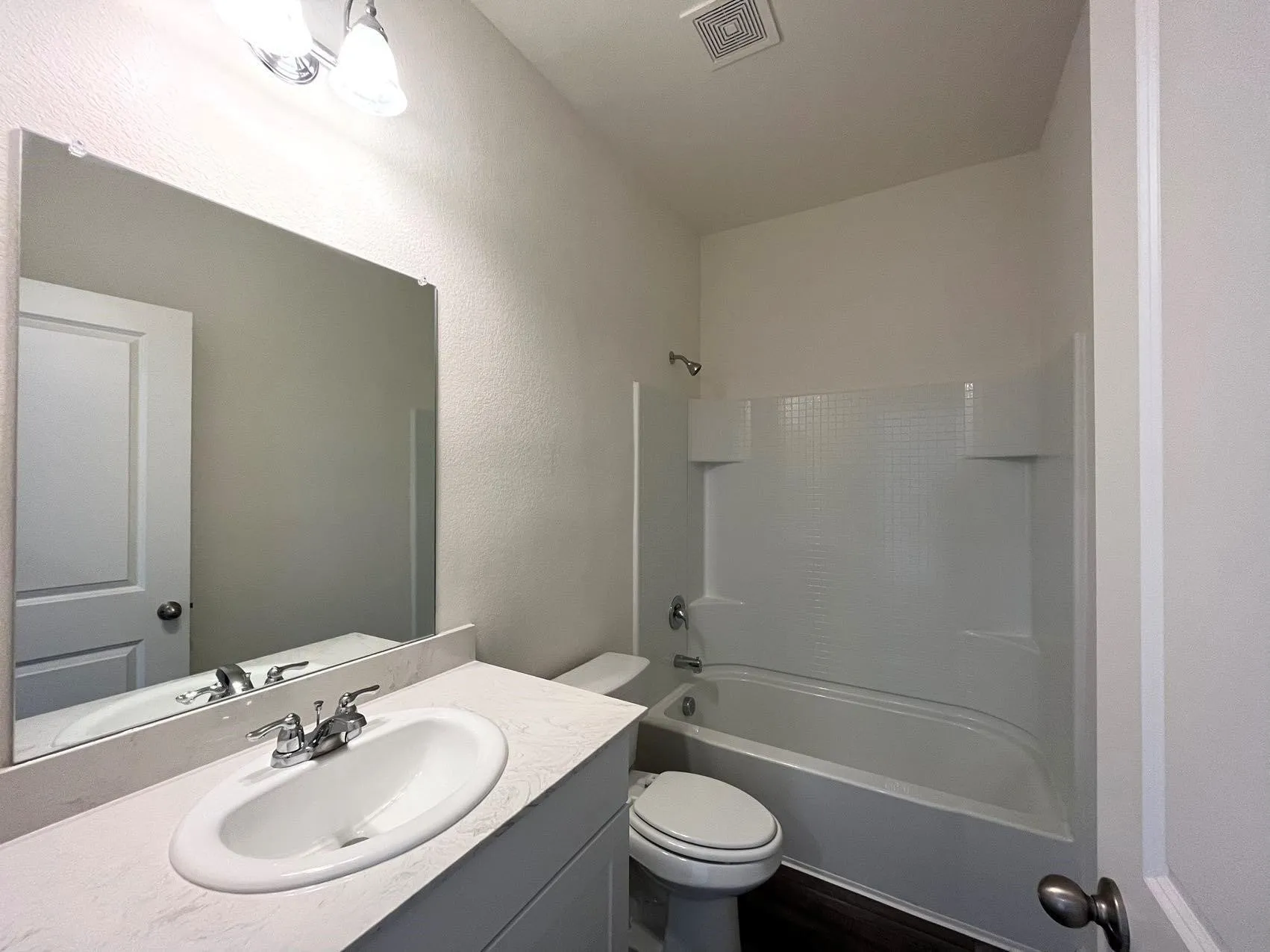 Bathroom featuring vanity, shower / bathtub combination, and a textured wall