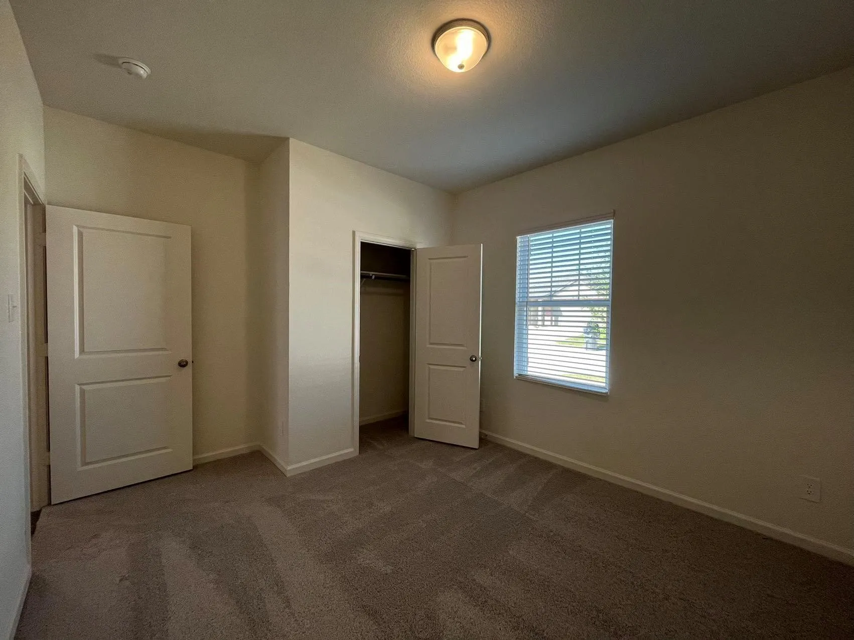 Unfurnished bedroom featuring dark carpet and a closet