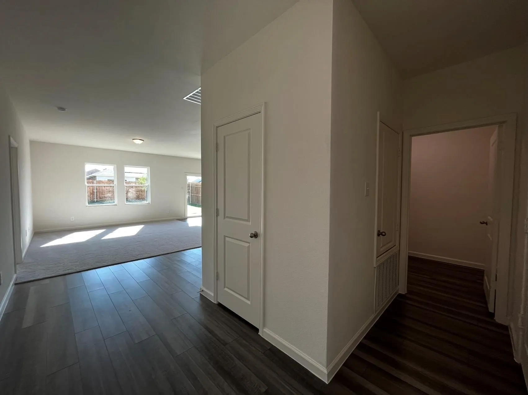 Hall with baseboards and dark wood-style flooring