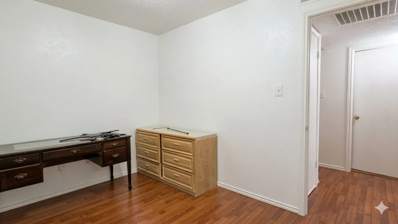 Bright interior room with wood-finish flooring, white walls, white trim, and a white ceiling