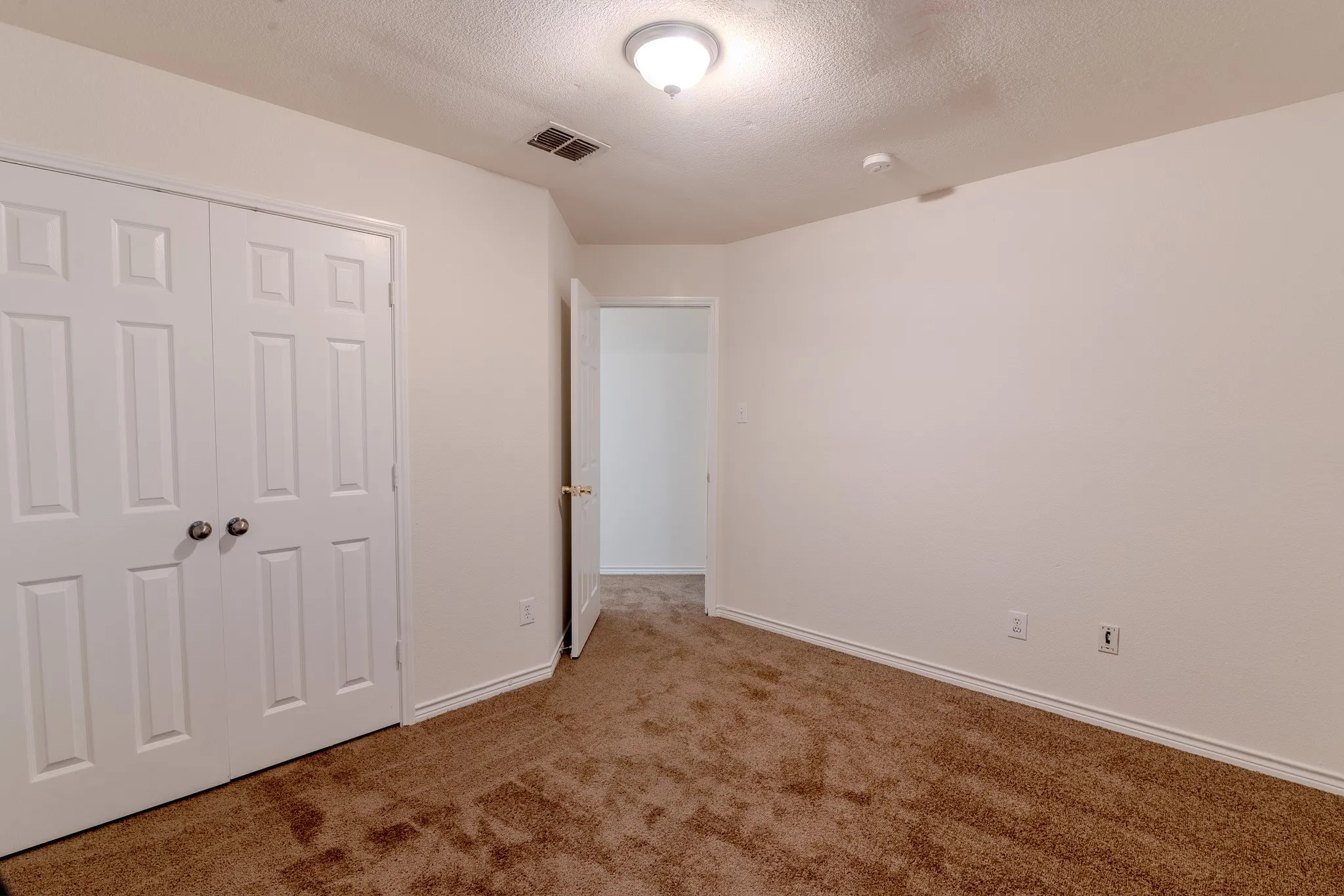 Bedroom featuring neutral wall paint, white baseboards, and brown carpeting
