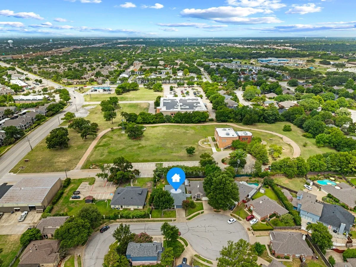 Aerial view of a residential neighborhood featuring established homes, mature trees, and a cul-de-sac street pattern