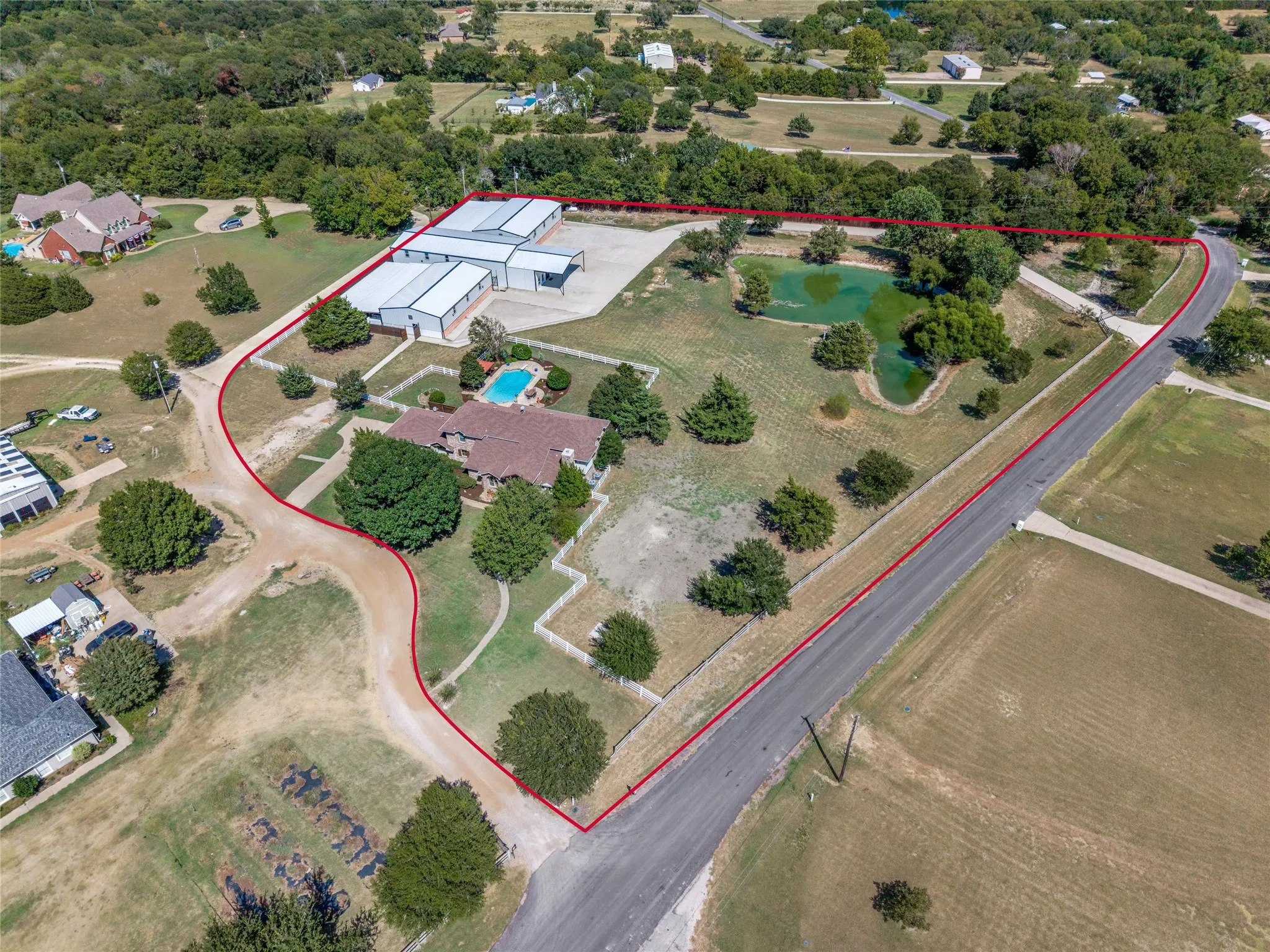 Expansive property featuring multiple outbuildings, an inground swimming pool, and two ponds