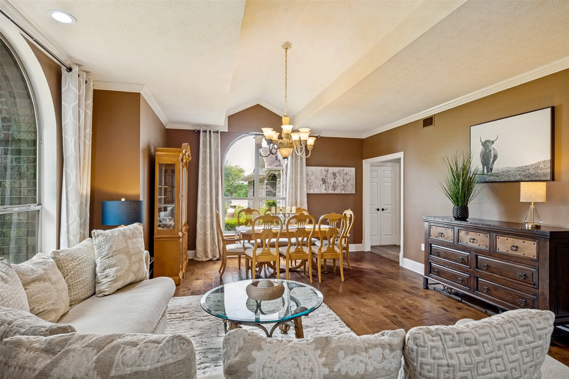 Vaulted ceilings accentuating the living and dining areas, featuring rich wood-finish flooring