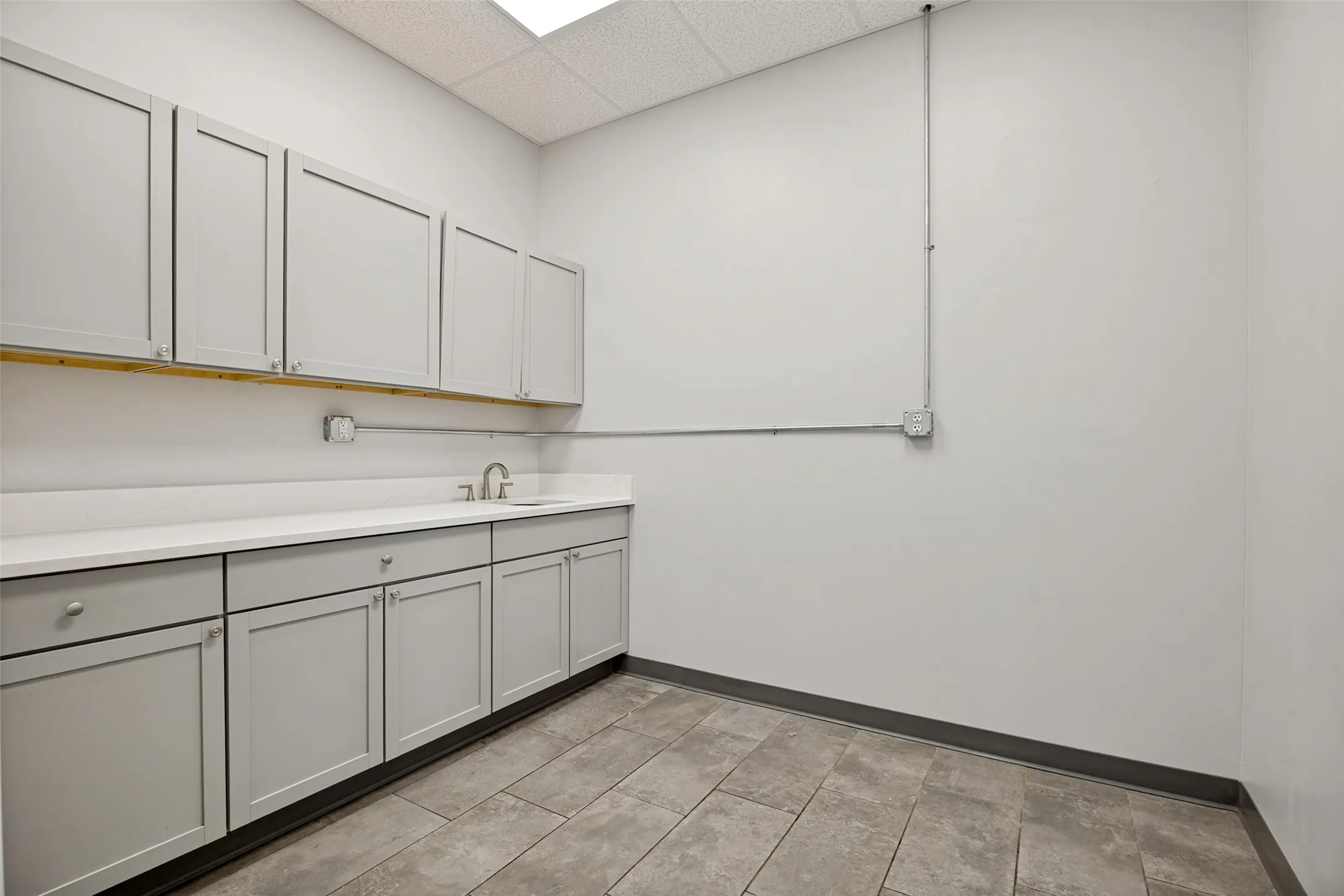 Lab room featuring lead walls for Xray equipment, built in cabinets, sink, tile floors