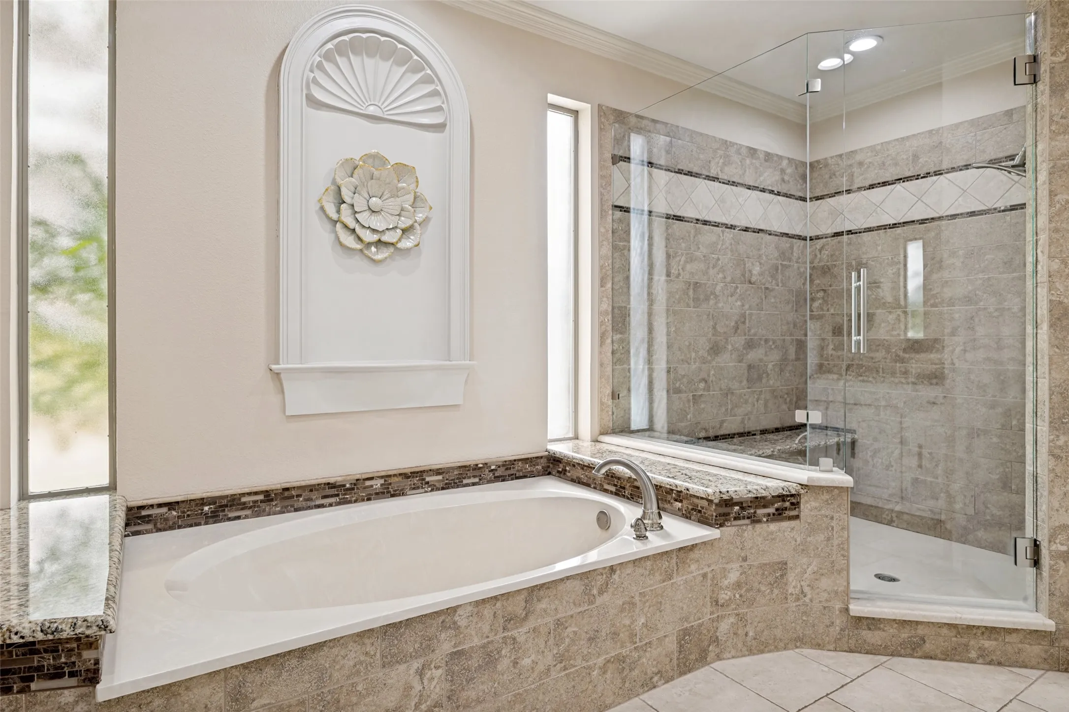 Soaking tub with deck-mounted faucet and mosaic tile surround