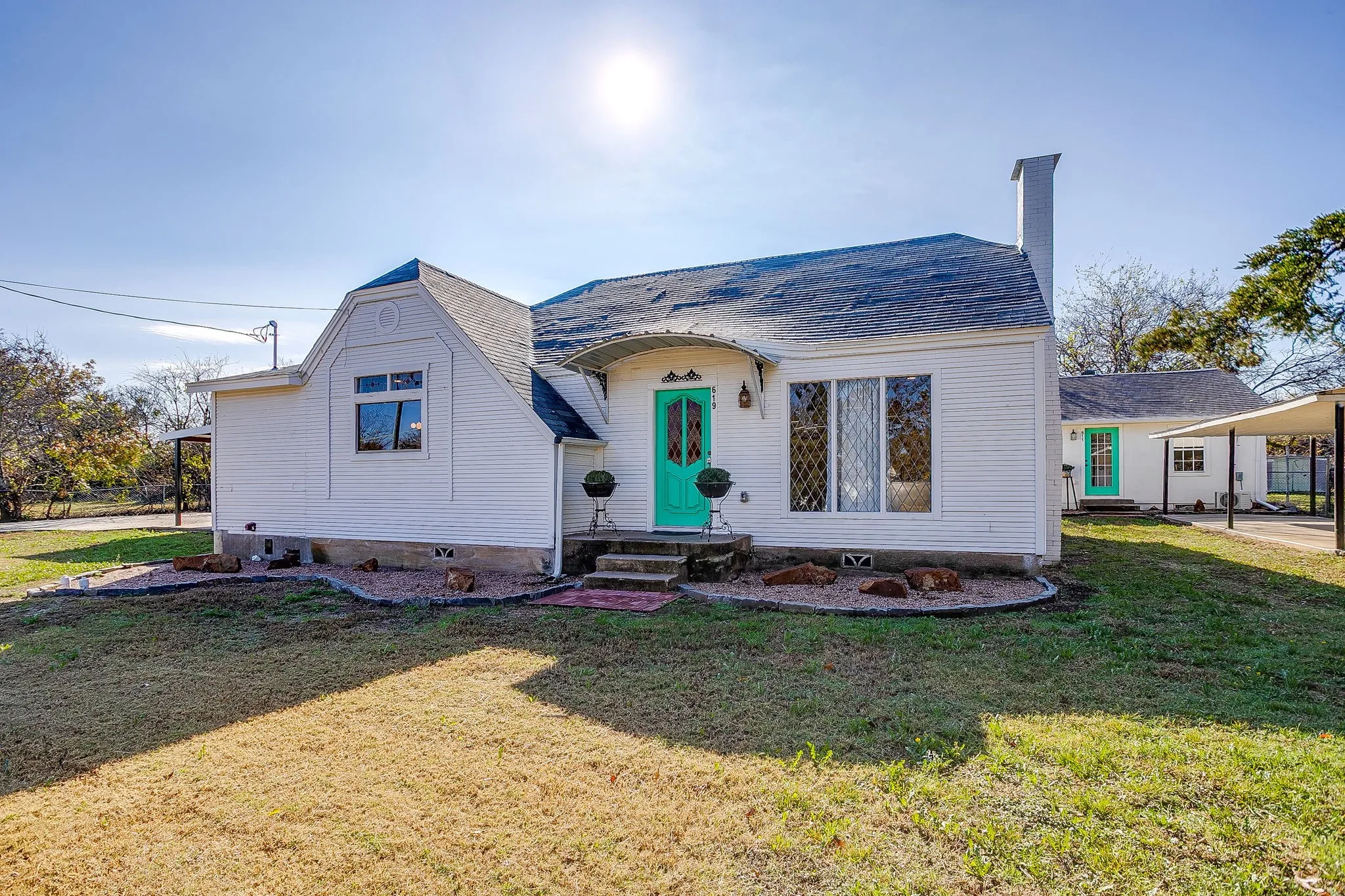 View of front of house with a chimney and a front lawn