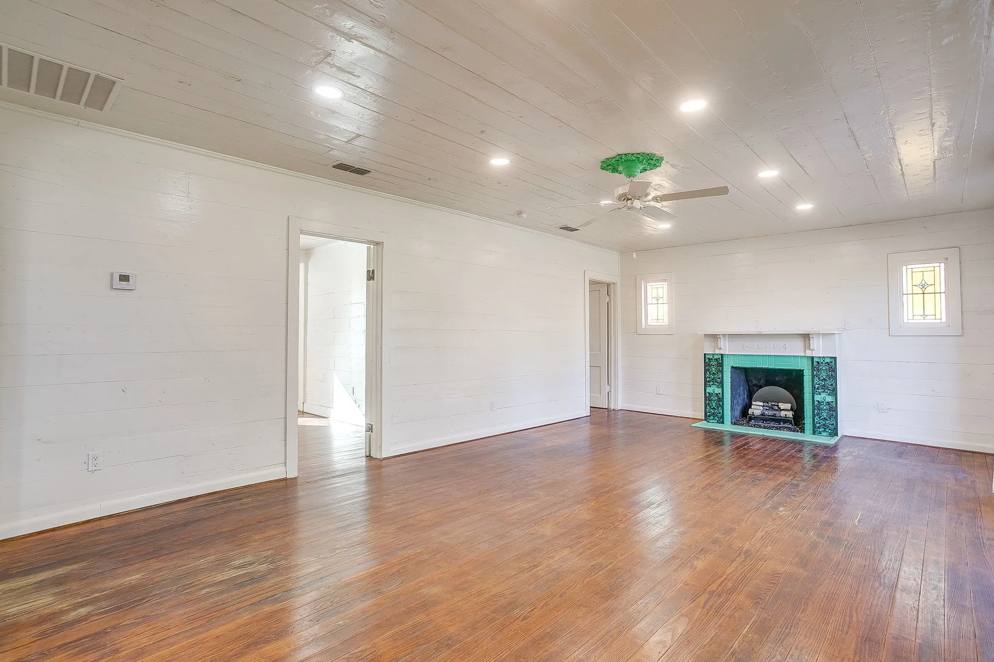Unfurnished living room featuring dark wood-style flooring, recessed lighting, a high end fireplace, ceiling fan, and wood ceiling
