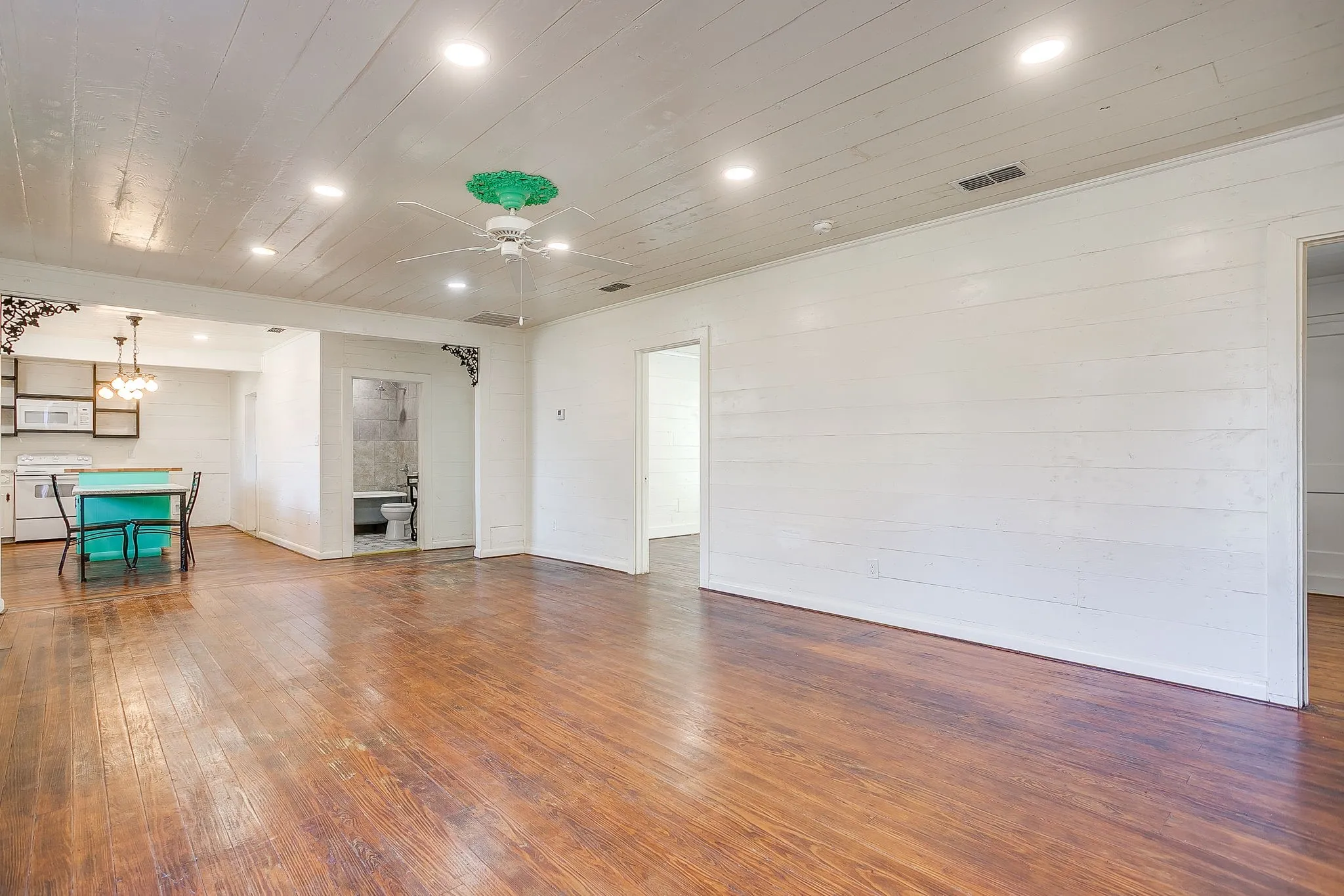 Unfurnished living room featuring hardwood / wood-style floors, recessed lighting, a chandelier, wood ceiling, and ceiling fan