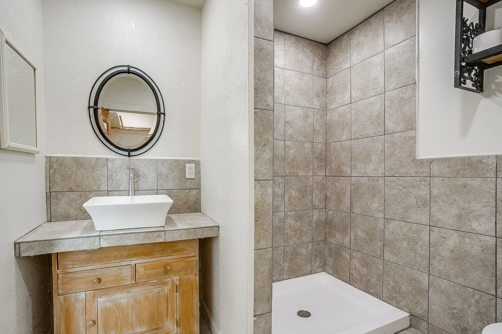 Full bath featuring vanity, a shower stall, and backsplash