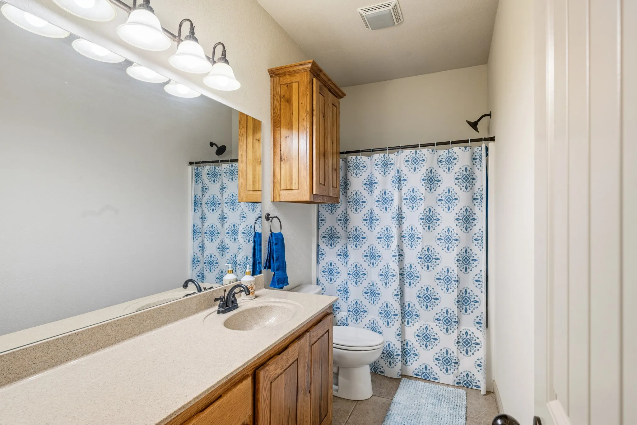 Secondary bathroom features built in storage and a shower tub combo.
