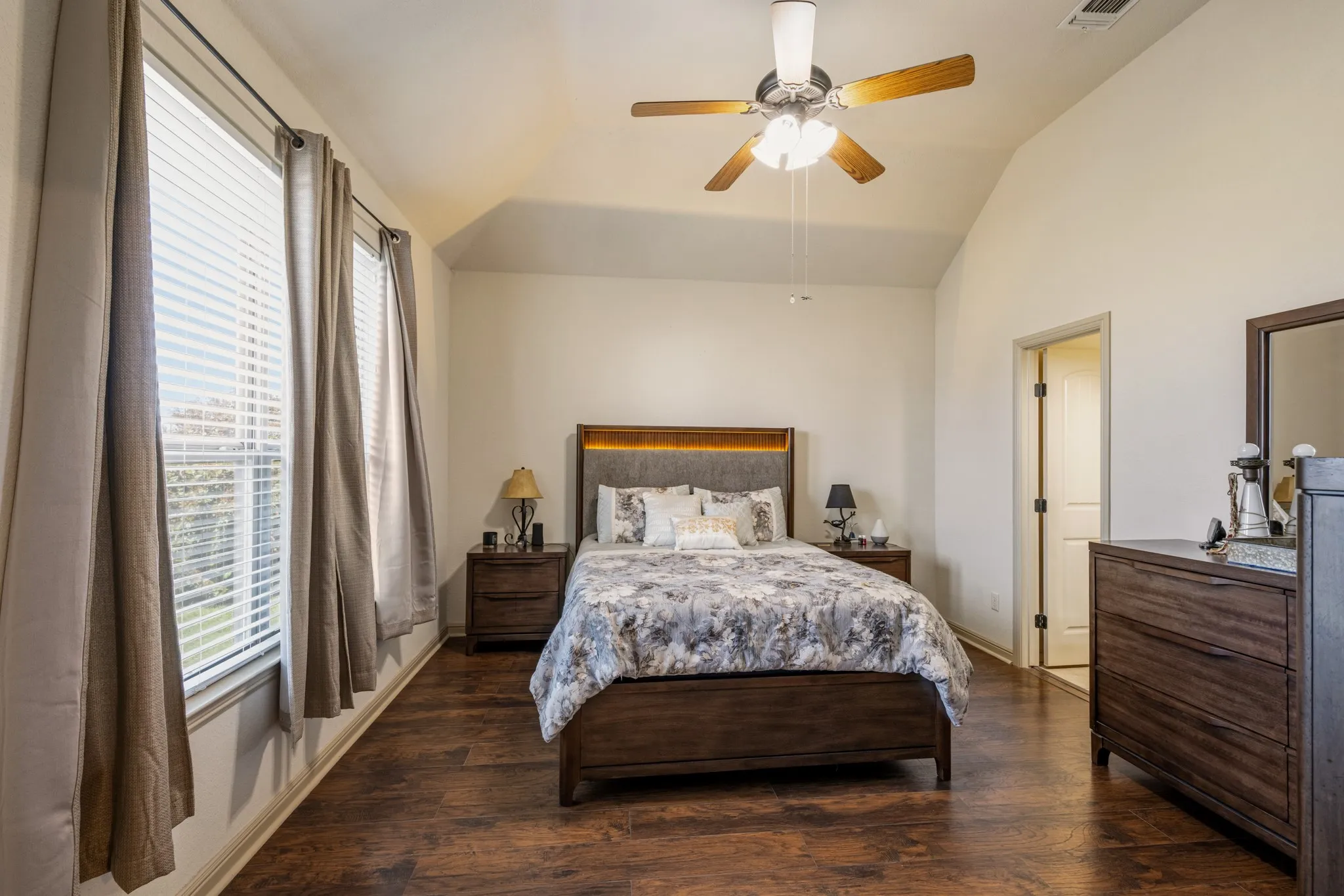 Large windows and tall ceiling give the primary bedroom an open and inviting feeling.